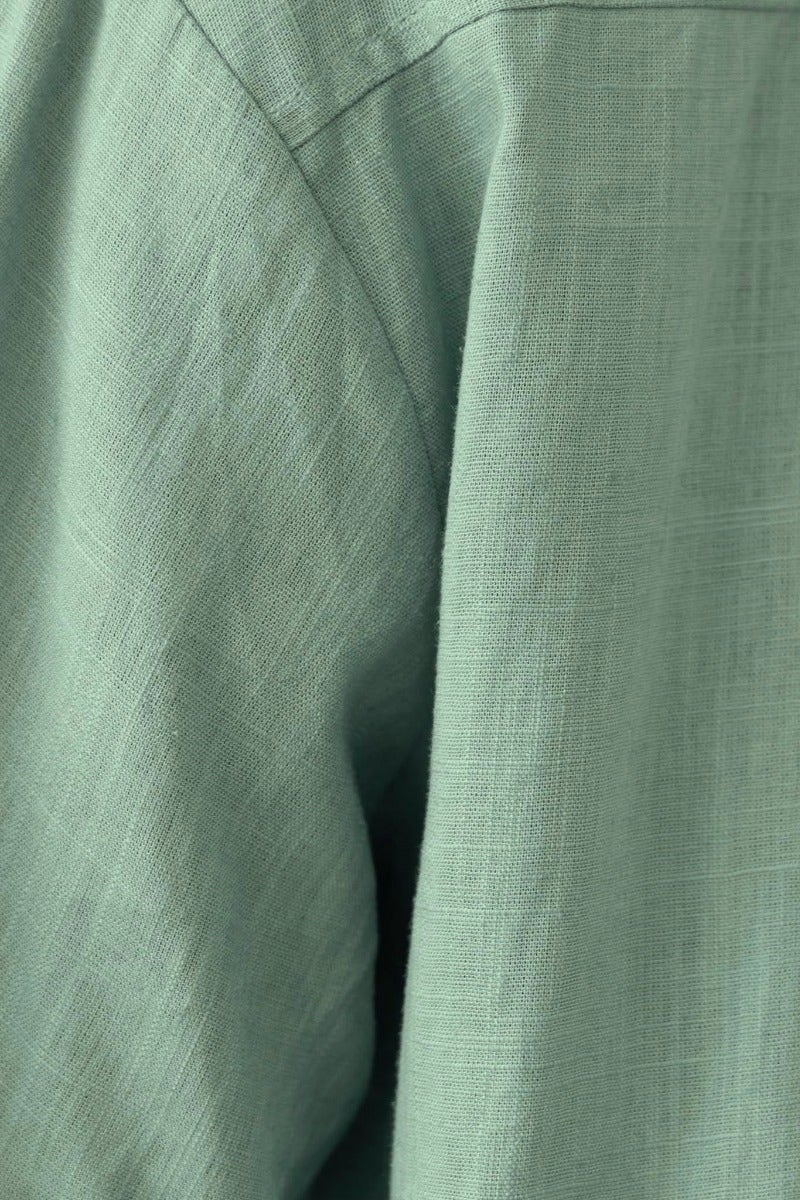 Close-up of the Take It Easy Top in green linen texture showing fabric detail and strapless design.