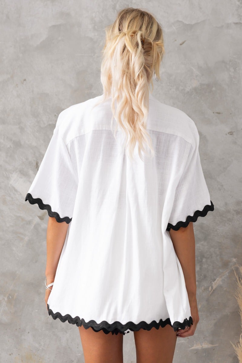 Back view of Take It Easy Shirt featuring a relaxed fit with scalloped black trim, styled with casual elegance.