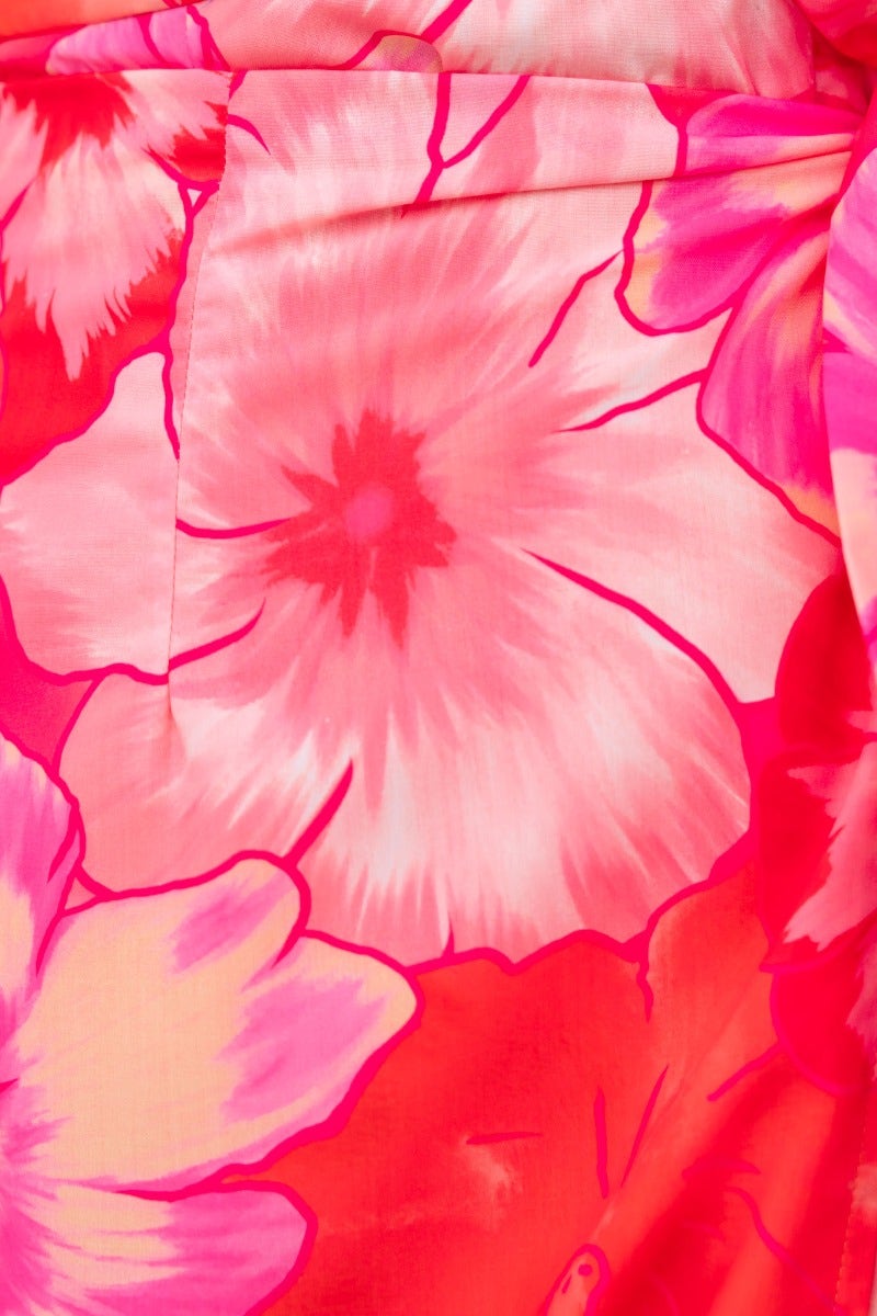 Close-up of vibrant floral print in pinks and reds for a stylish midi dress.