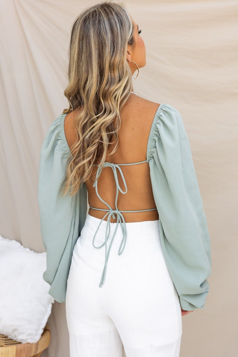 Model wearing the Flaria Top with a sweetheart neckline and open back featuring tie details.
