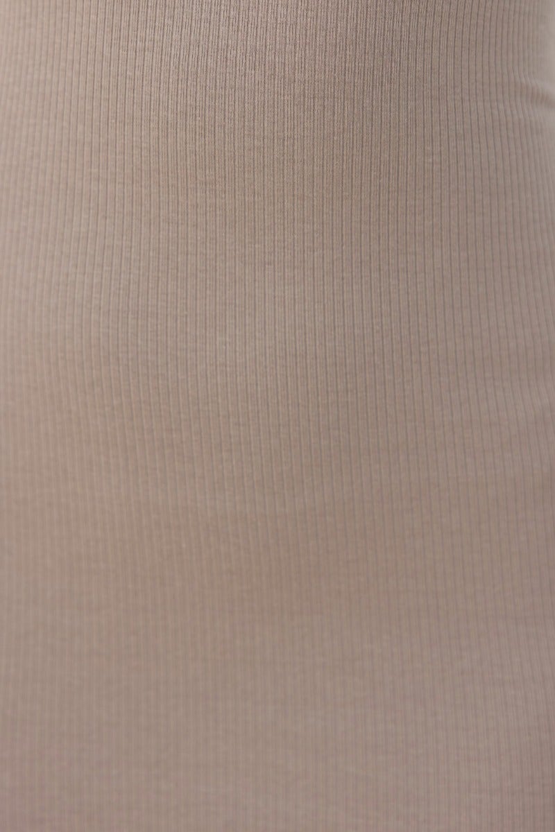 Close-up of ribbed fabric texture in a soft beige color, showcasing stretch for comfort and style.