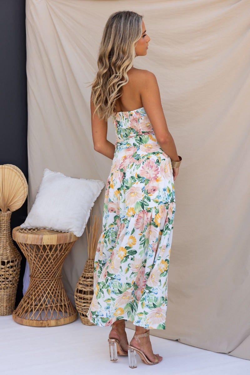 Model showcasing Blaine Maxi Dress with a floral print, strapless design, and elegant back view against neutral backdrop.