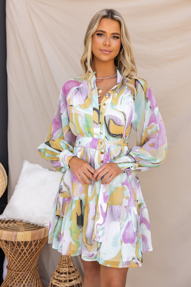 Model wearing Orazio multi-colour print dress with high neckline and button-up front, styled with removable belt.