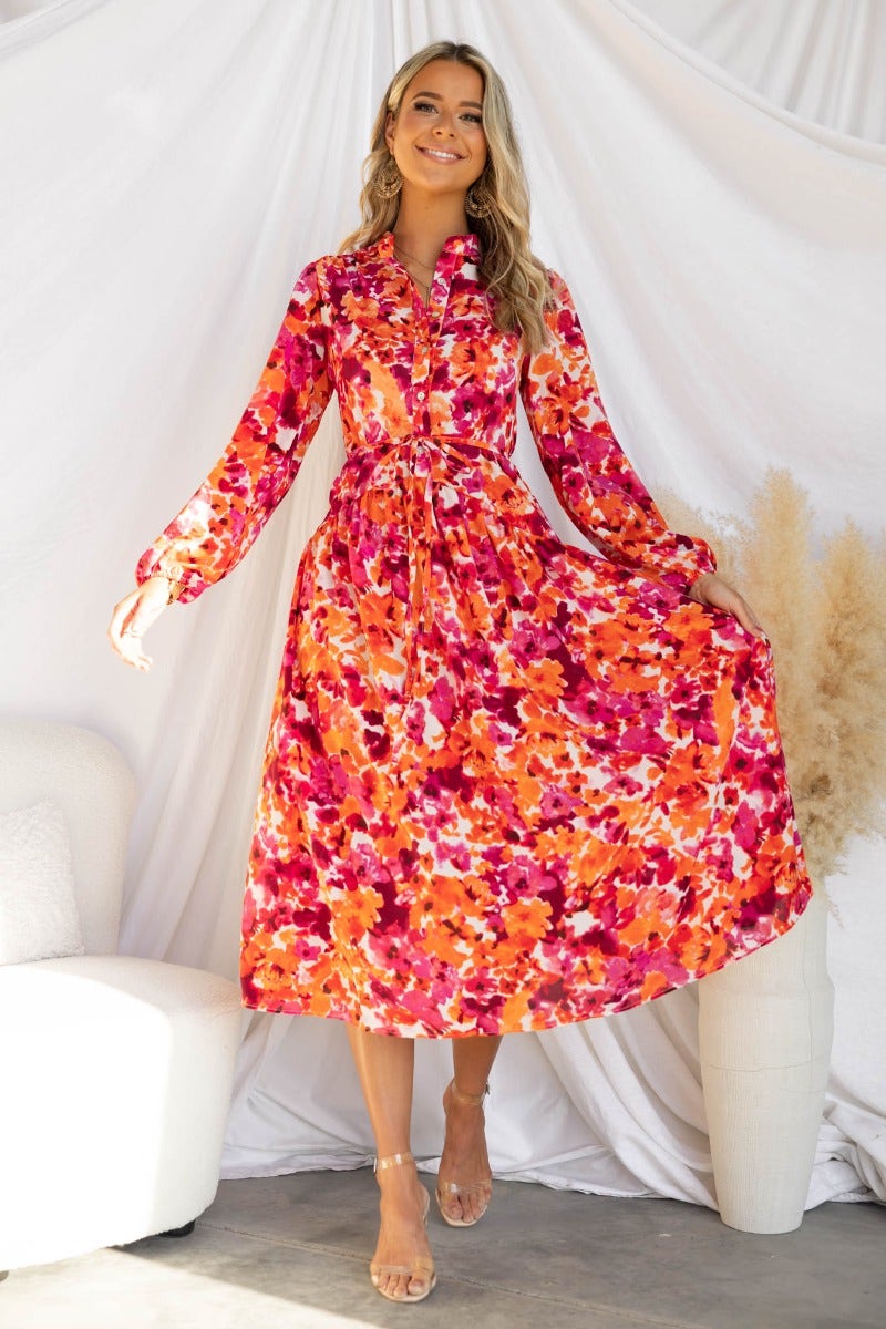 Floral print midi dress with high neckline and button-up bust, featuring elastic cuffs and flowing skirt.