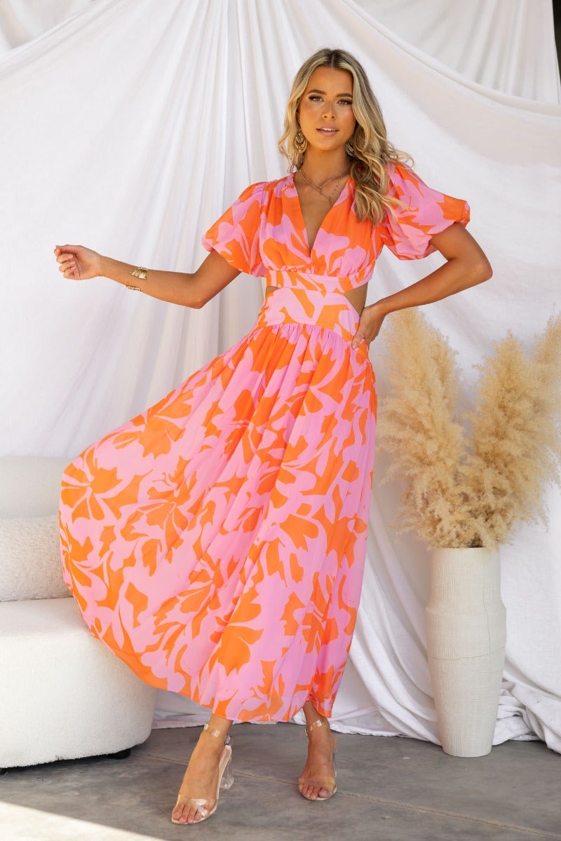 Floral print Marleen Maxi Dress in pink and orange with V-neckline and cut-out waist, perfect for summer occasions.