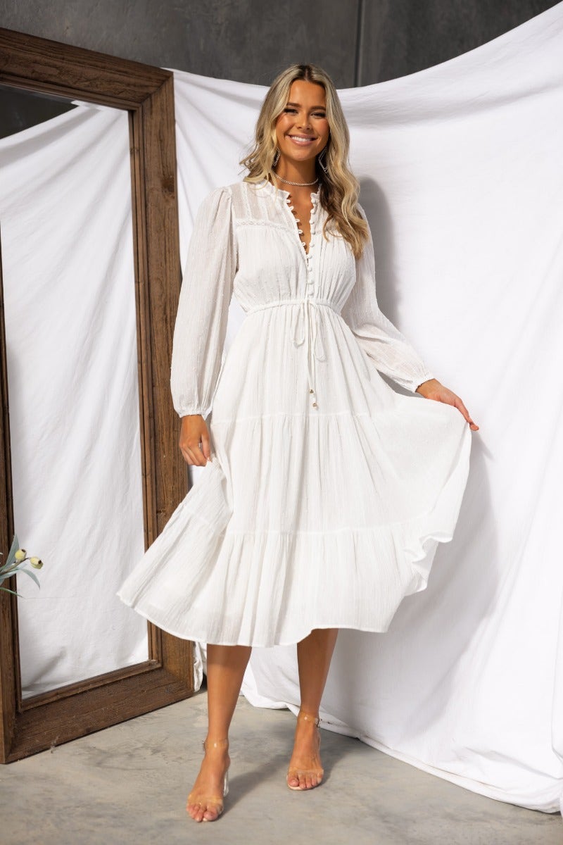 Woman wearing a white Rayna Midi Dress with button-up bust, elastic waistband, and pockets.