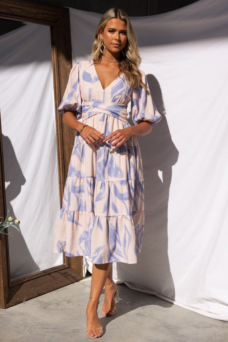 Elegant Orchi Midi Dress in soft pastel floral pattern, featuring V-neckline and elastic sleeves, perfect for casual outings.