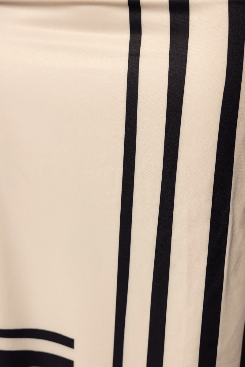Close-up of the striped pattern on the Fayte Midi Dress, featuring black stripes on a cream background.