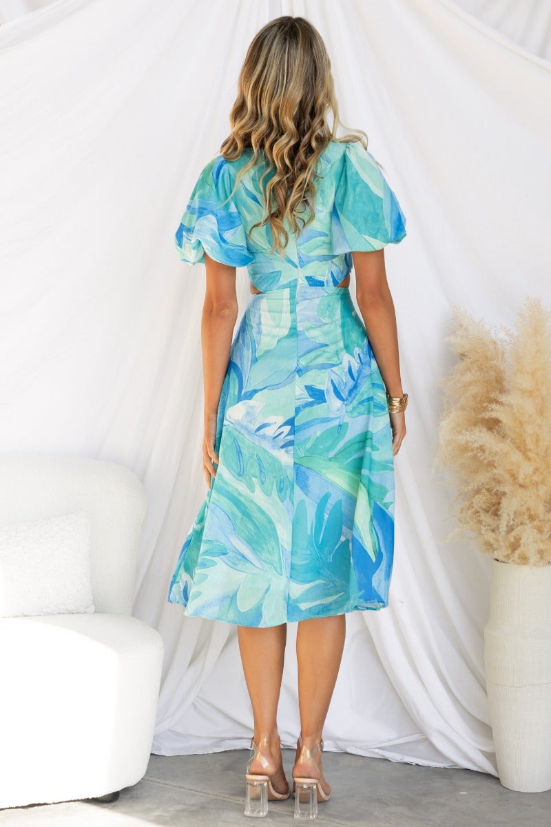 Back view of Ayla Midi Dress featuring a vibrant leaf print and stylish flutter sleeves.