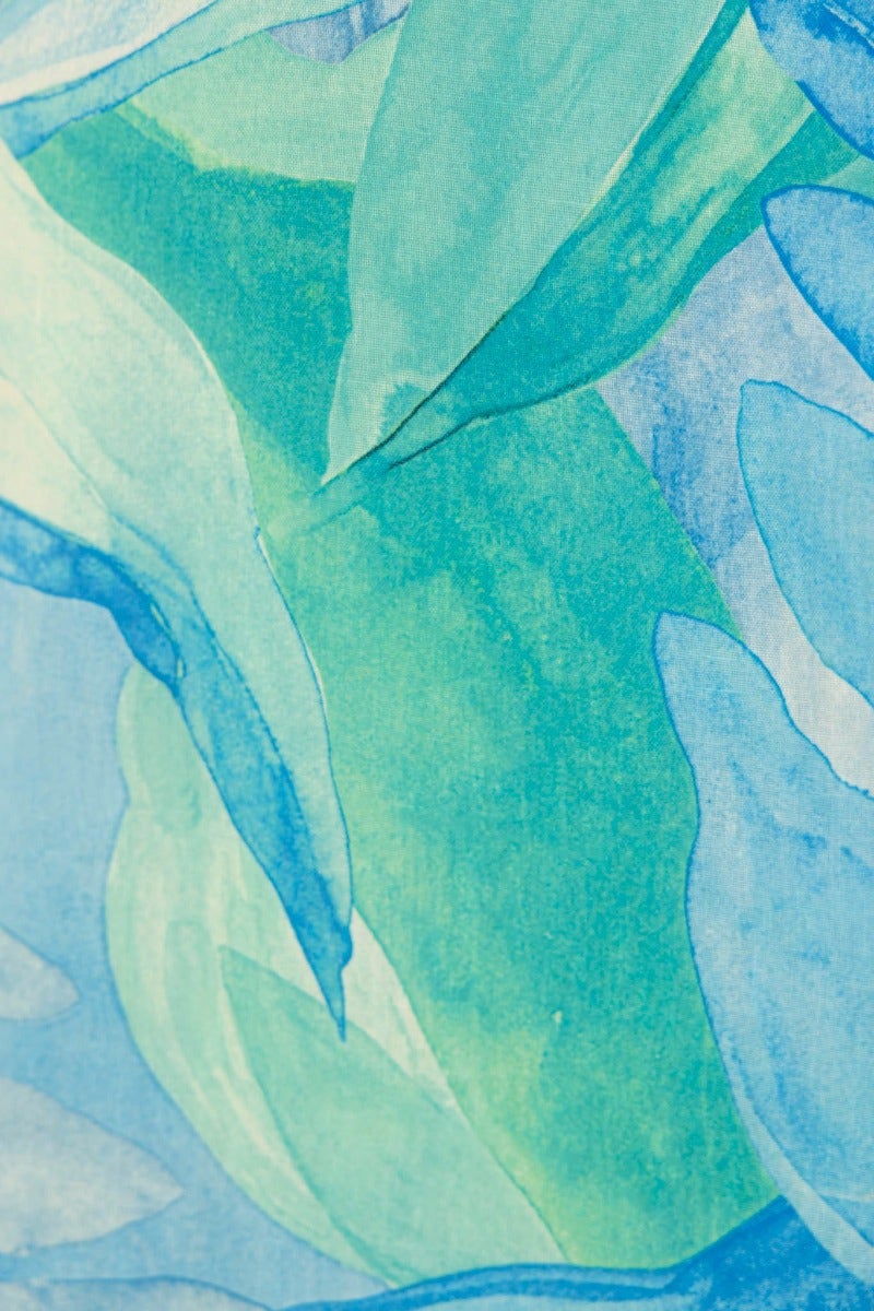 Multi-colour fabric featuring a watercolor-style design with shades of blue and green leaves.