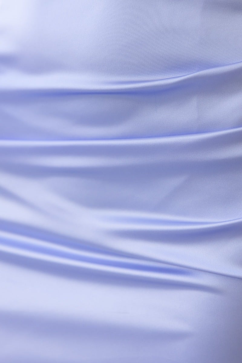 Close-up of soft satin fabric texture in light blue, showcasing elegant folds and draping of the Marbelle Midi Dress.