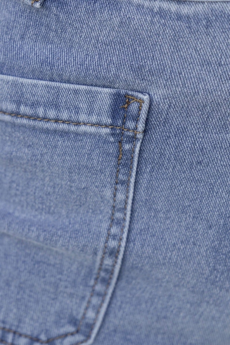 Close-up of a pocket on a Mora denim midi skirt, showcasing the light blue fabric and stitching details.