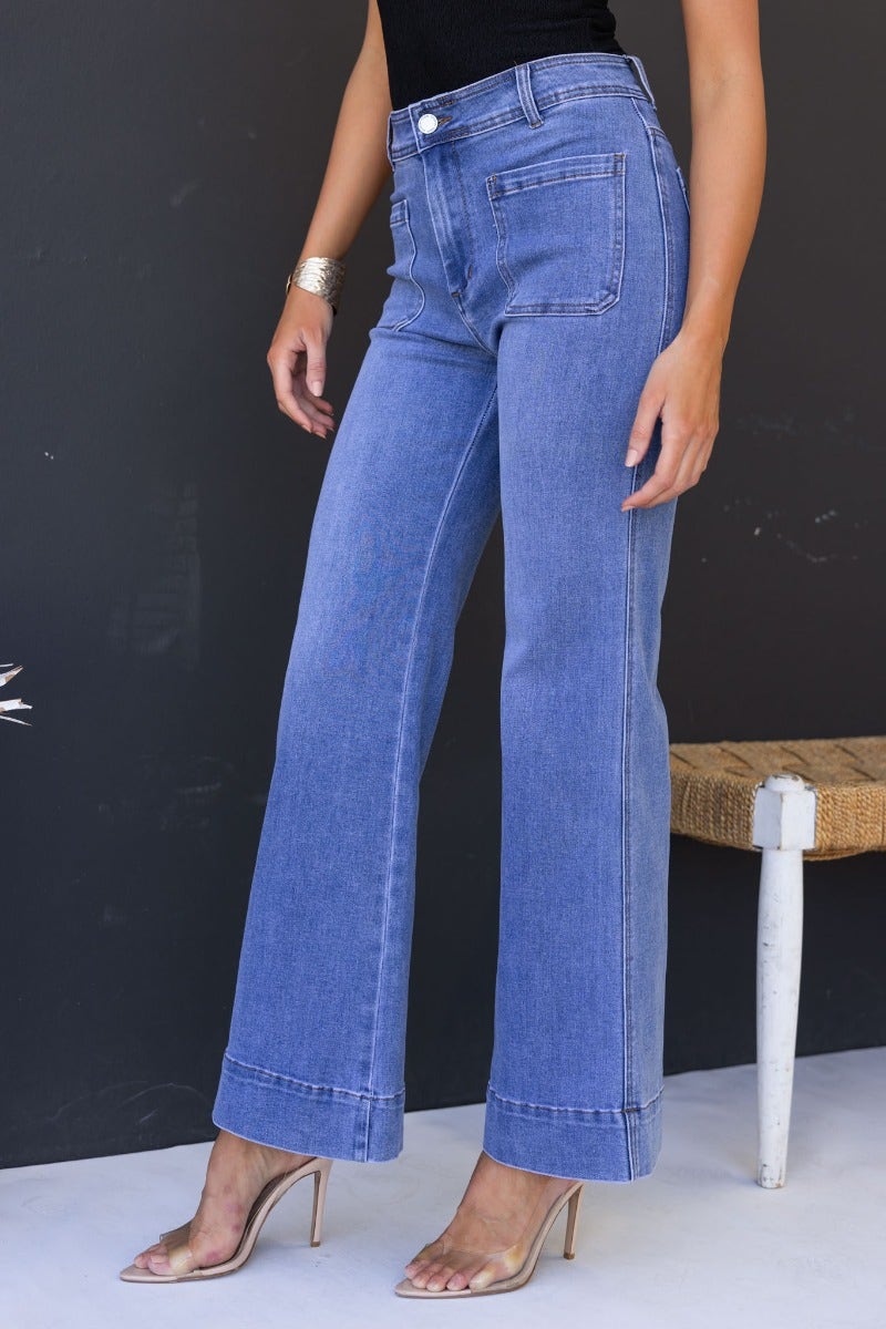 Lane Jeans featuring mid-high waist fit, stretch denim, and front & back pockets, styled with heels.