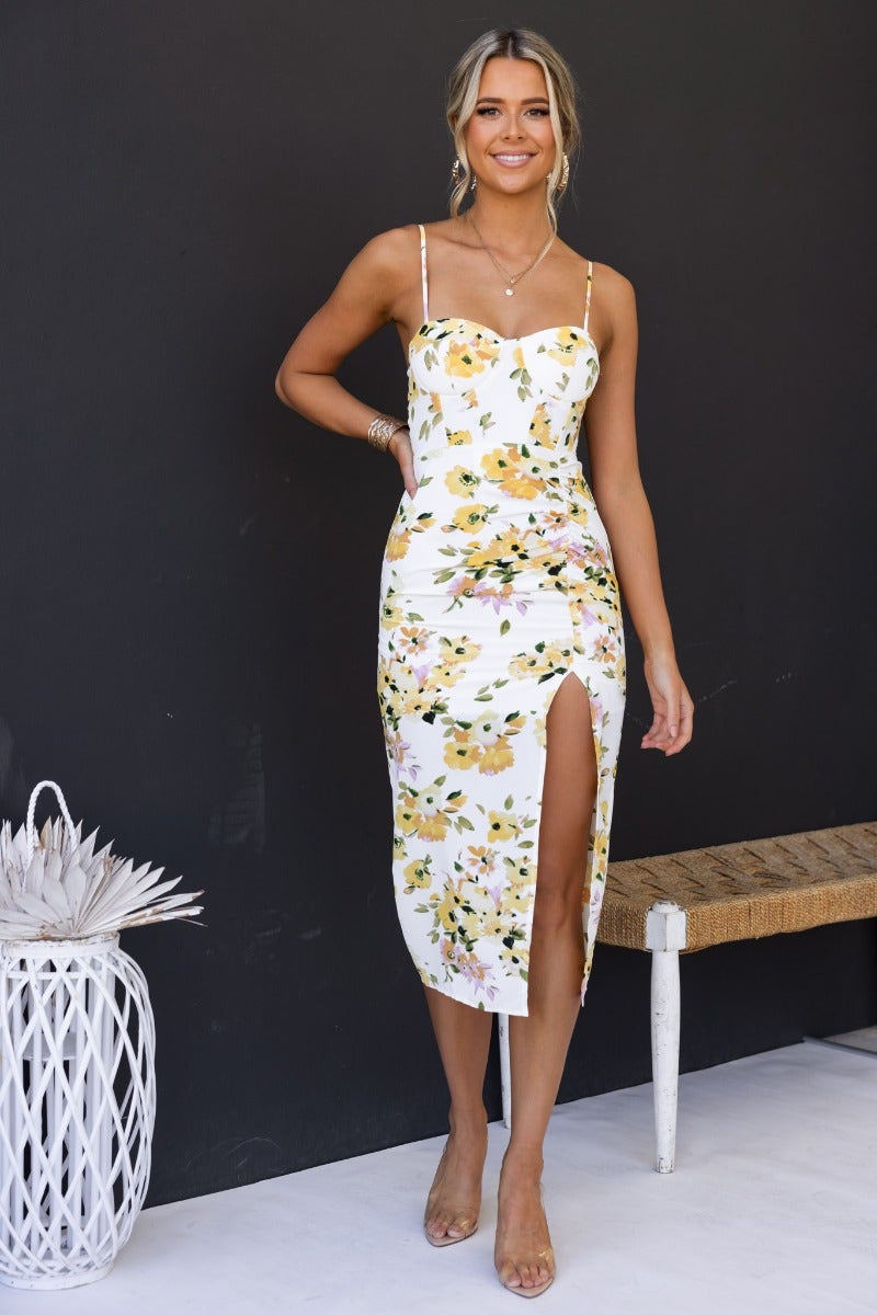 Model wearing Zephyr Midi Dress with floral print, featuring adjustable straps and high split.