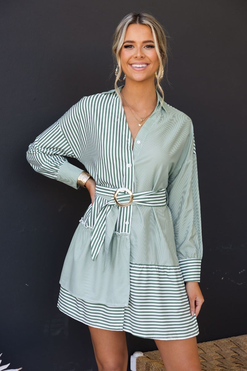 Model wearing a green striped Tiller Dress with a collar, button-up front, and a removable belt.
