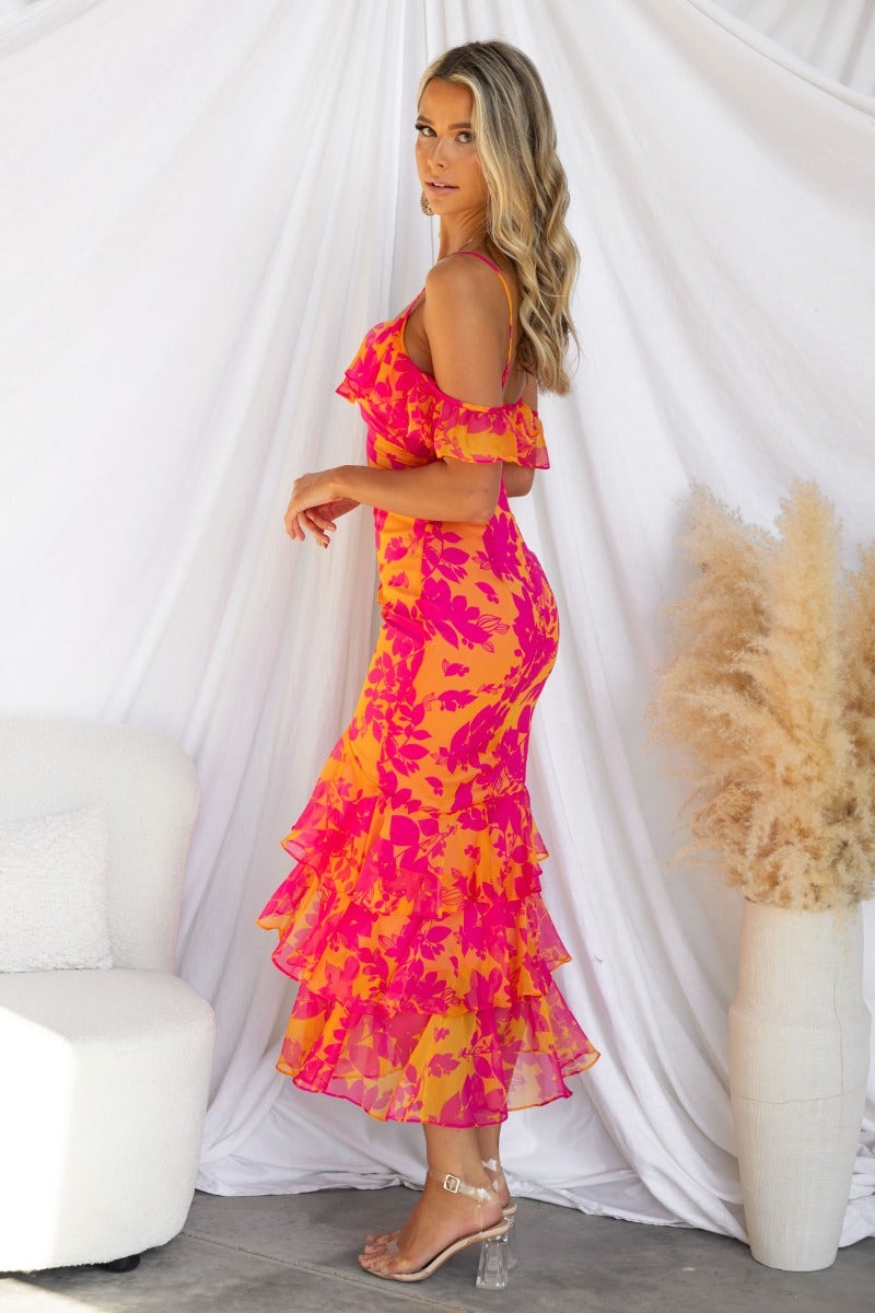 Model wearing a floral print Costa Rica maxi dress with off-shoulder ruffle sleeves and a multi-tier skirt.