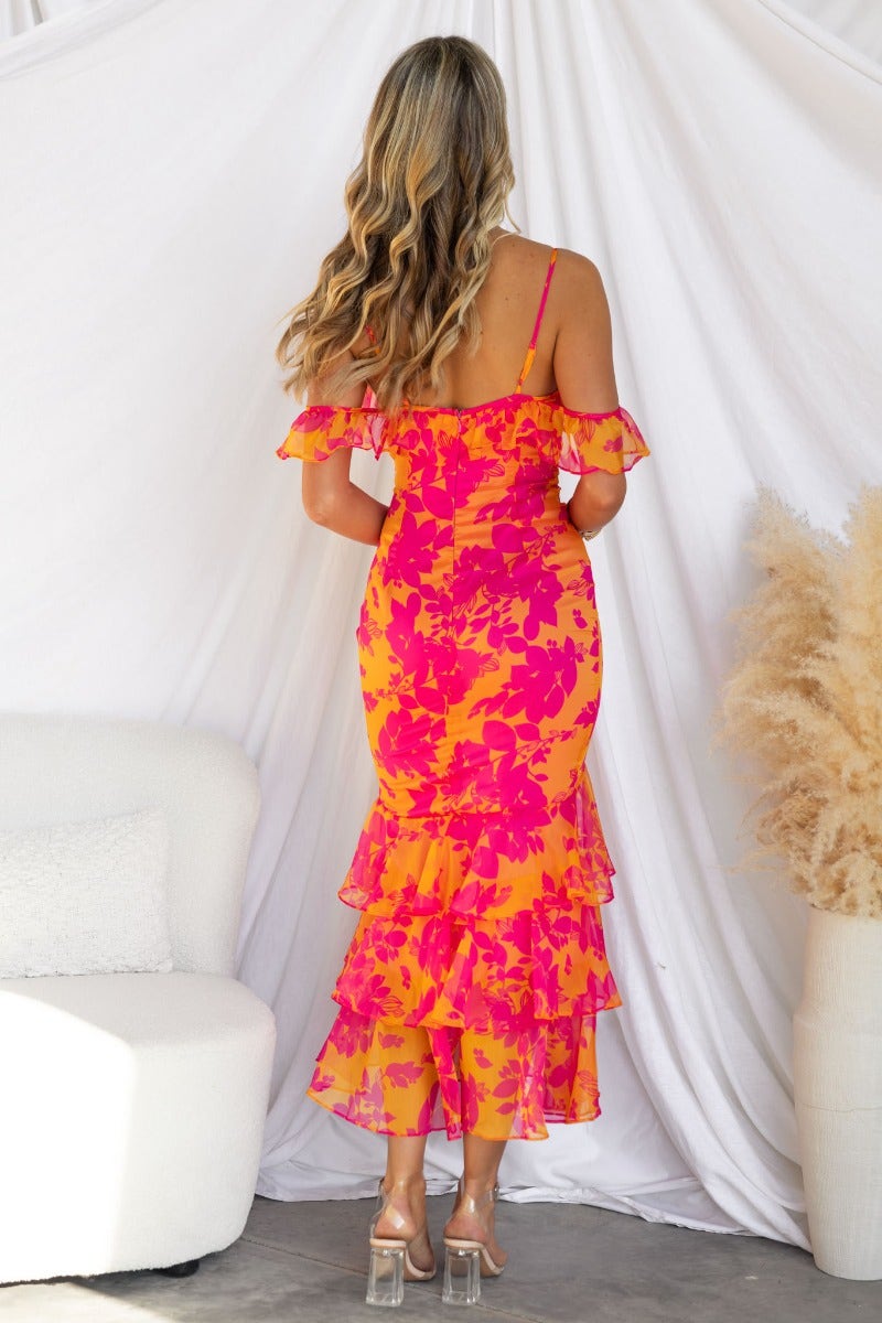 Back view of a floral print Costa Rica maxi dress with off-shoulder ruffle sleeves and multi-tiered skirt.