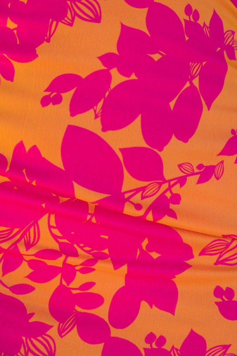 Bright floral print featuring bold pink leaves on an orange background, ideal for fashion and summer designs.