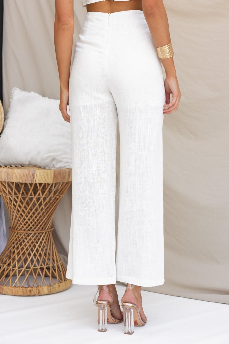 Back view of Reed Pants in linen blend, featuring mid-high waist fit and wide leg design, styled with a chic top.