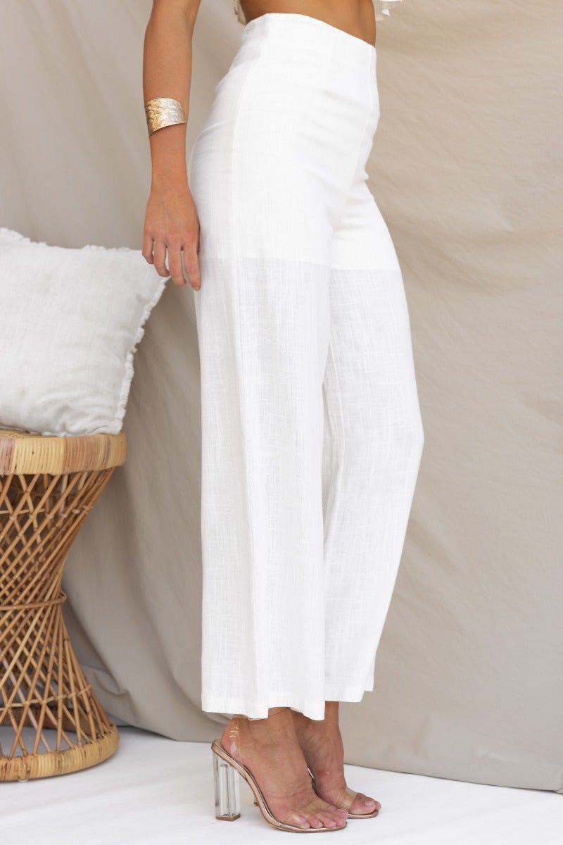 White linen blend Reed Pants with mid-high waist and elegant wide legs, styled with clear heels.