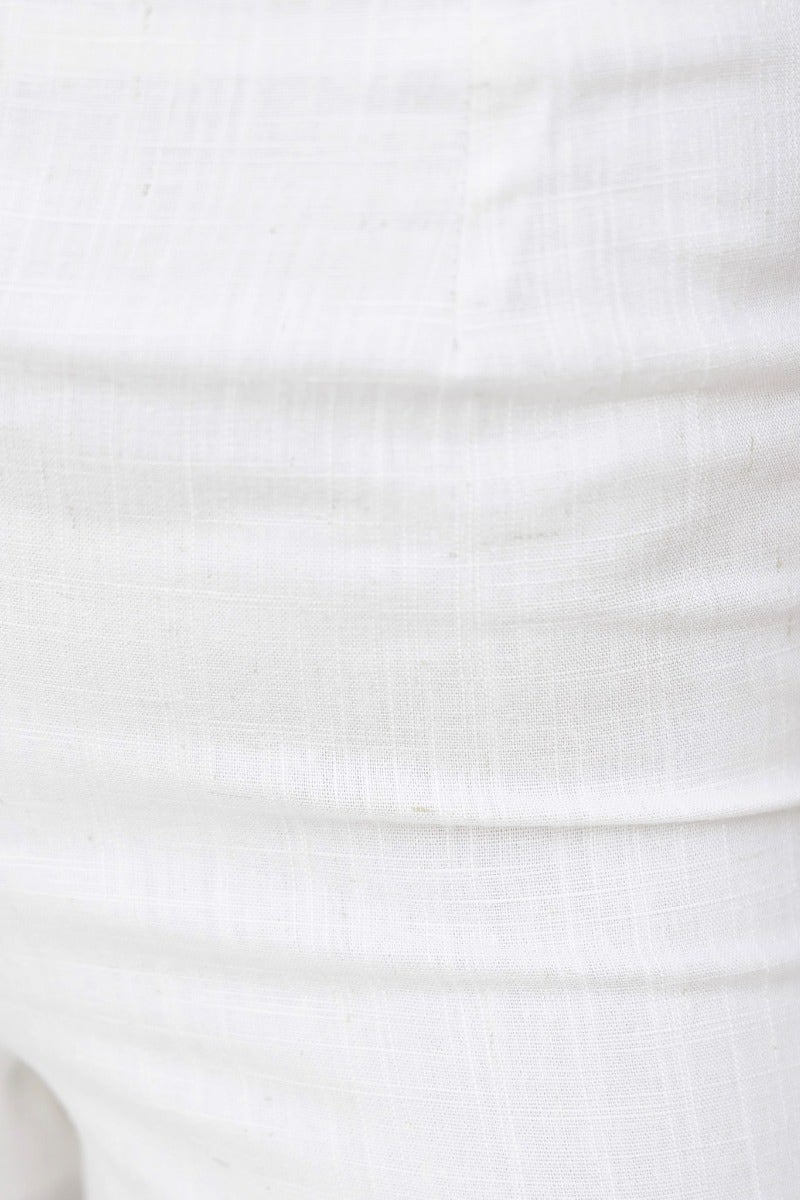 Close-up of a textured white linen blend fabric featuring a subtle weave pattern.
