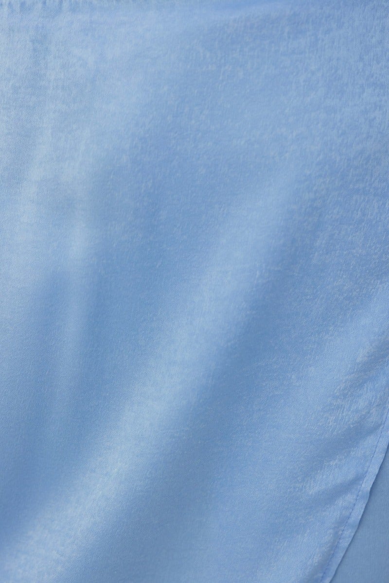 Close-up of soft blue fabric, showcasing texture and sheen, ideal for wraps and skirts.