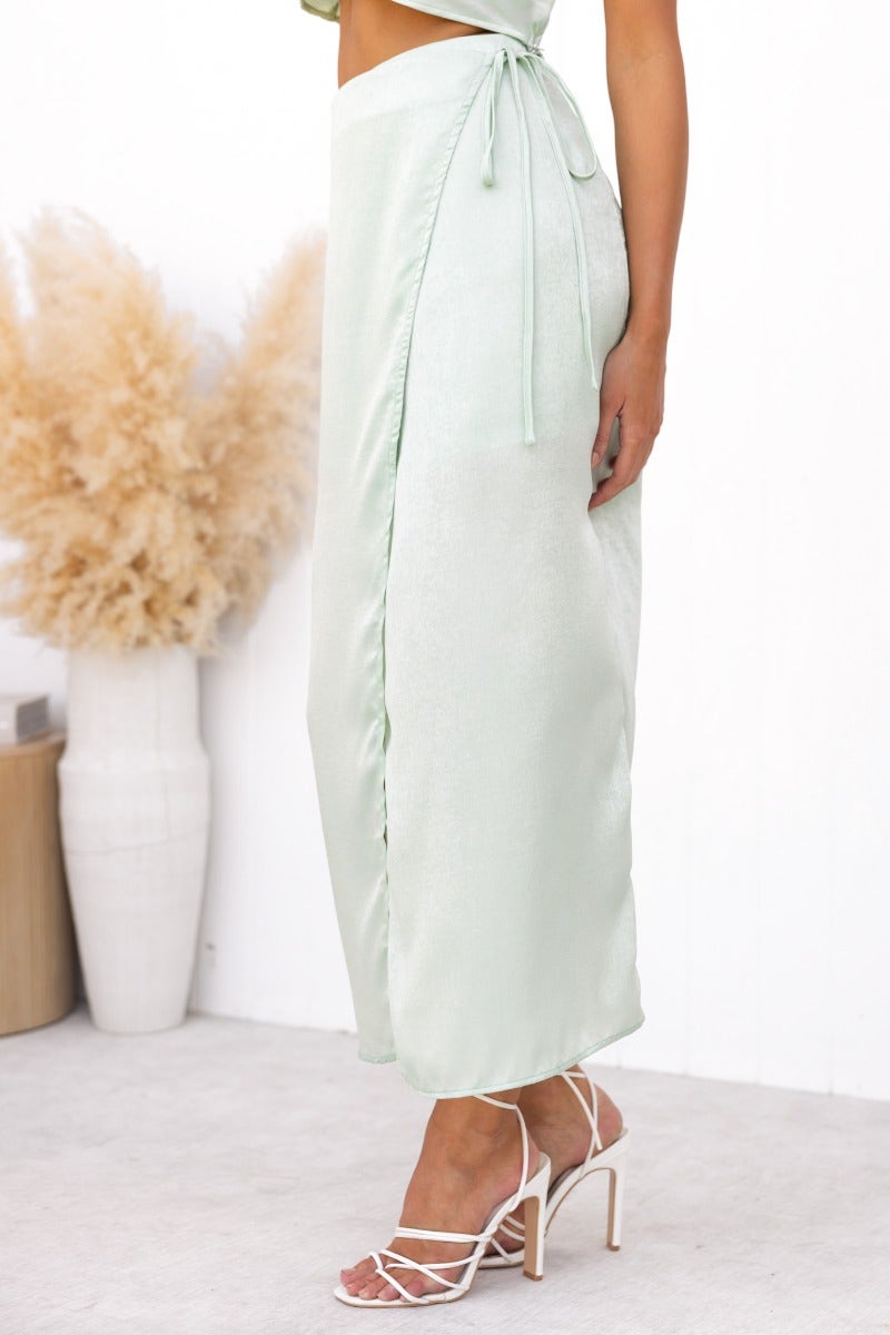 Nerida Wrap Midi Skirt in soft green with fabric tie and asymmetric hem details.