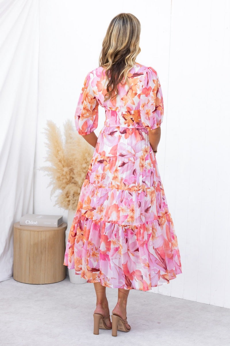 Floral print Orchi midi dress with V-neckline, elastic sleeves, and tiered skirt, shown from the back.