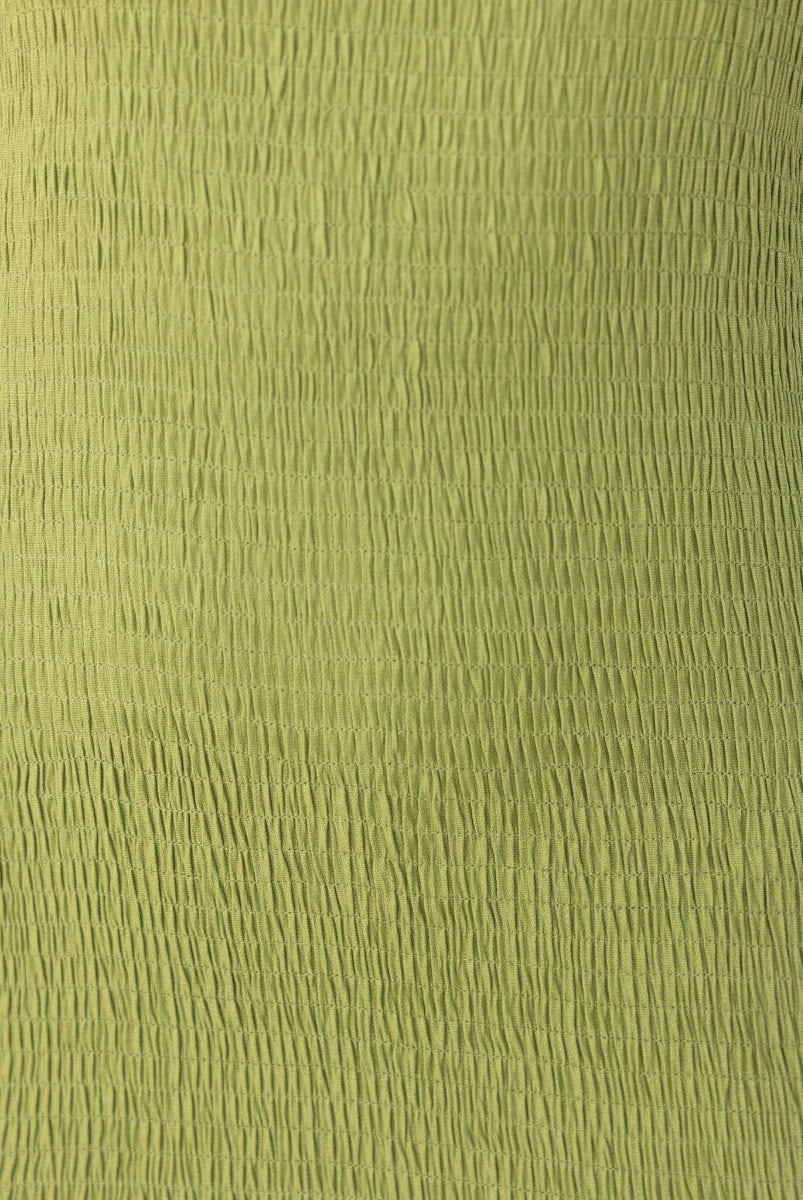 Texture close-up of stretchy green fabric used in the Dionne Midi Dress, showcasing its shirred design.