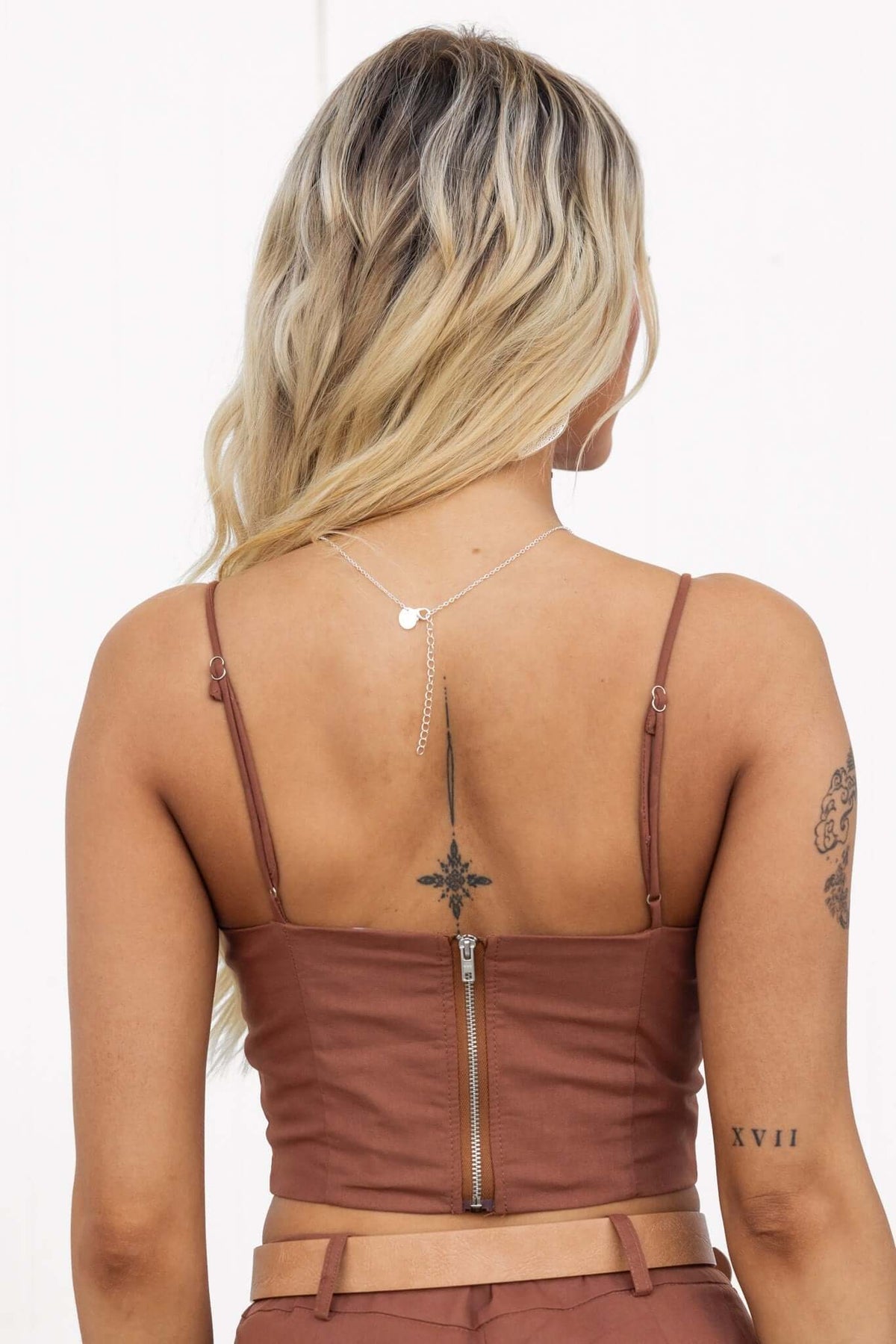 Back view of Downtown Top featuring adjustable spaghetti straps and a zip-up closure in a stylish brown color.
