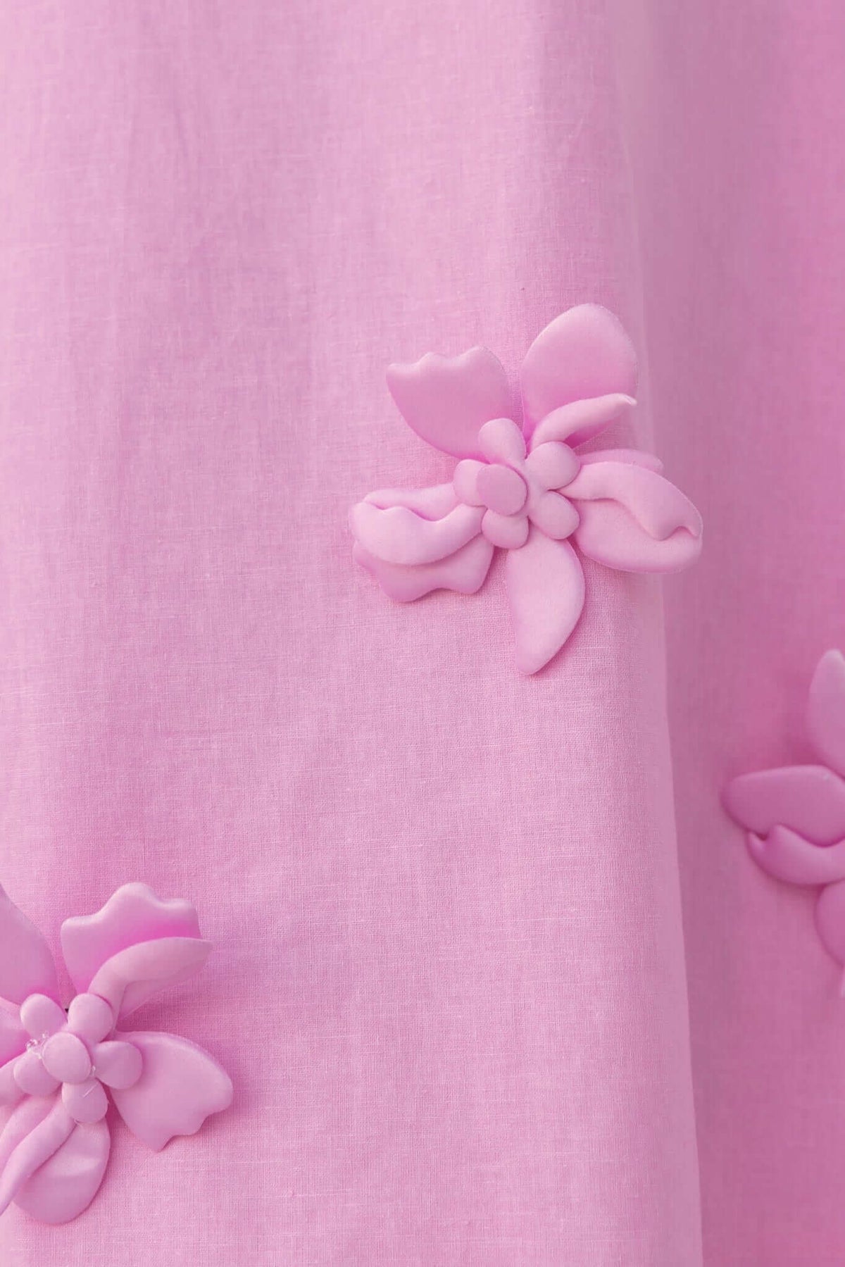 Close-up of removable pink flower embellishments on the Flower Pop Midi Dress, showcasing a delicate linen texture.