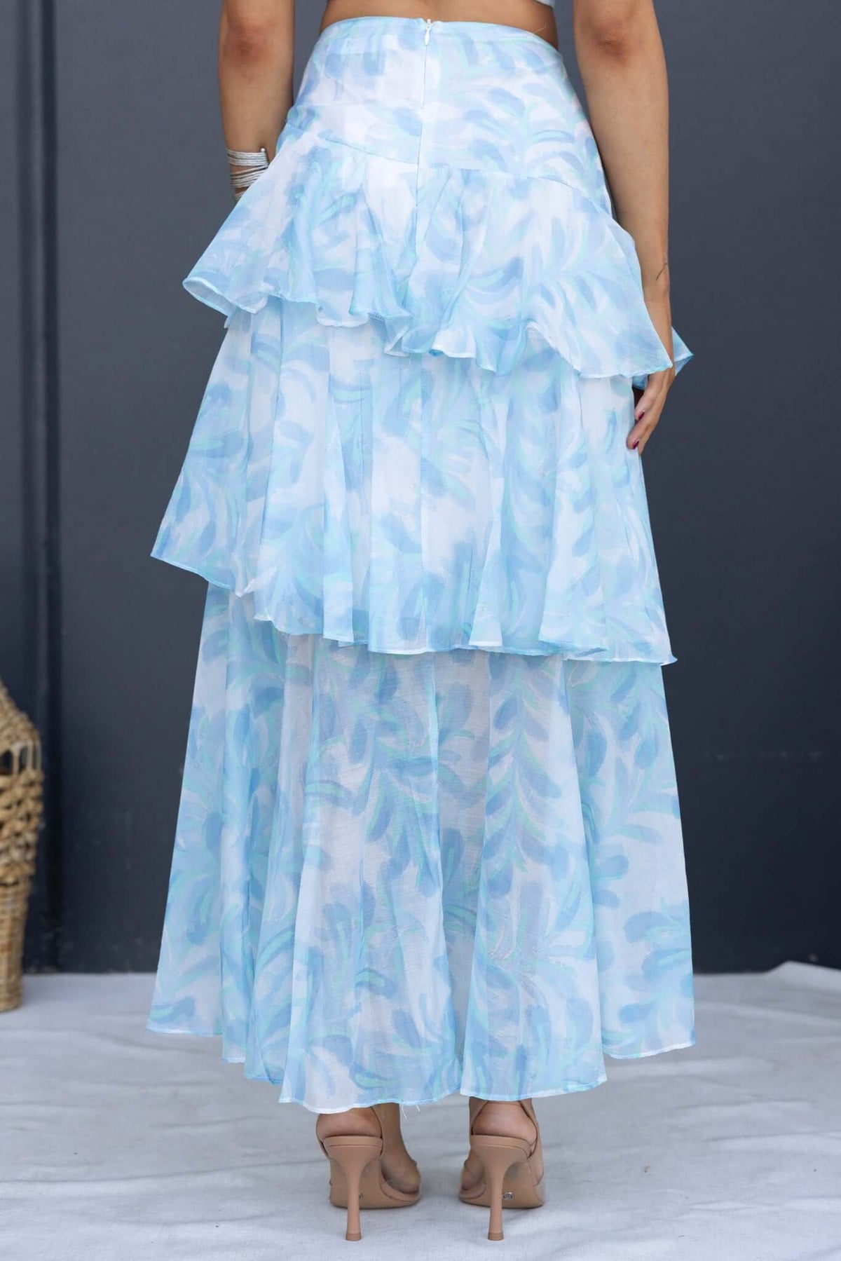Back view of Saphina floral print maxi skirt with tiered ruffles in light blue chiffon, showcasing its elegant design.