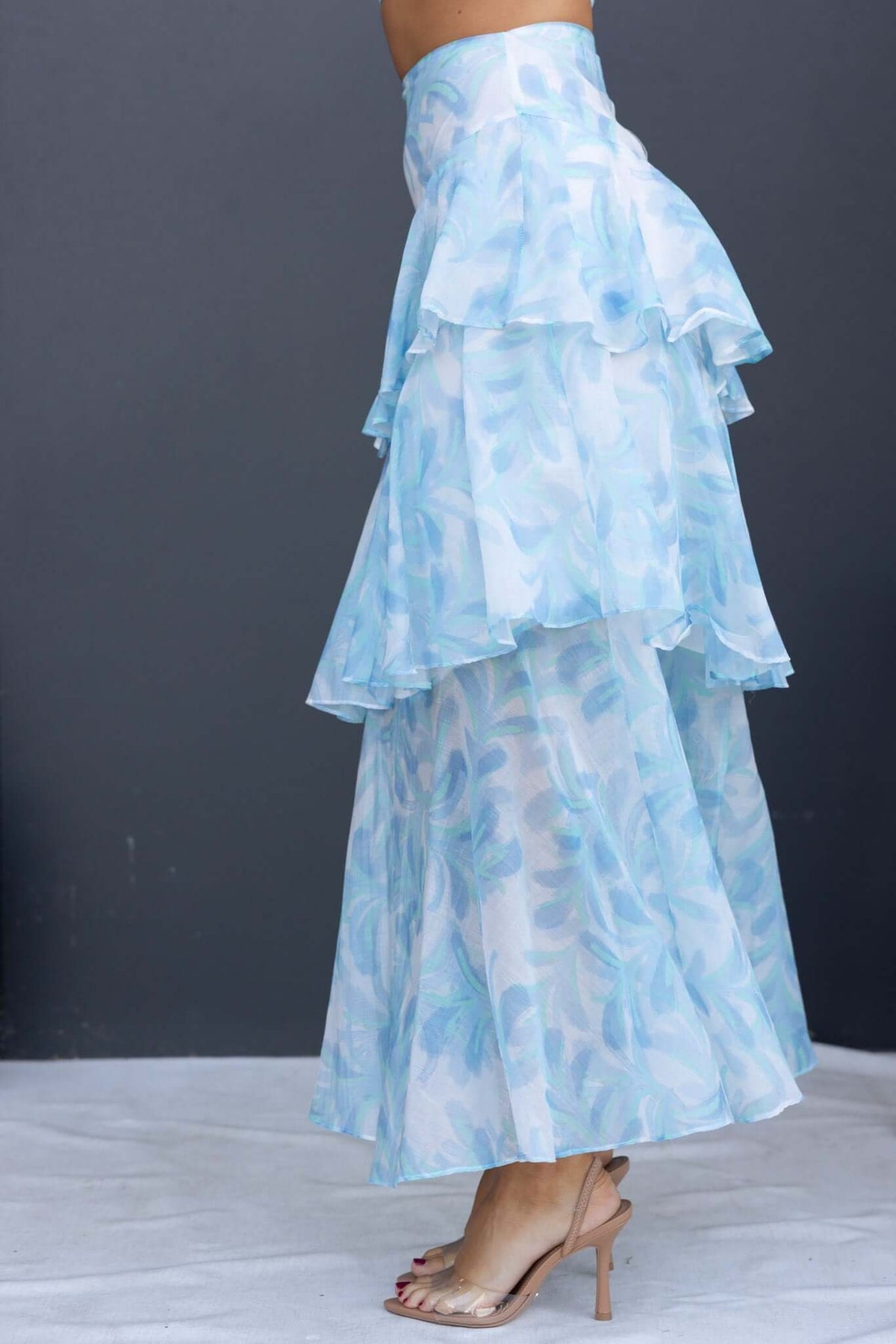 Saphina Maxi Skirt featuring a multi-tier ruffle hem and floral print in soft blue chiffon, perfect for stylish summer outfits.