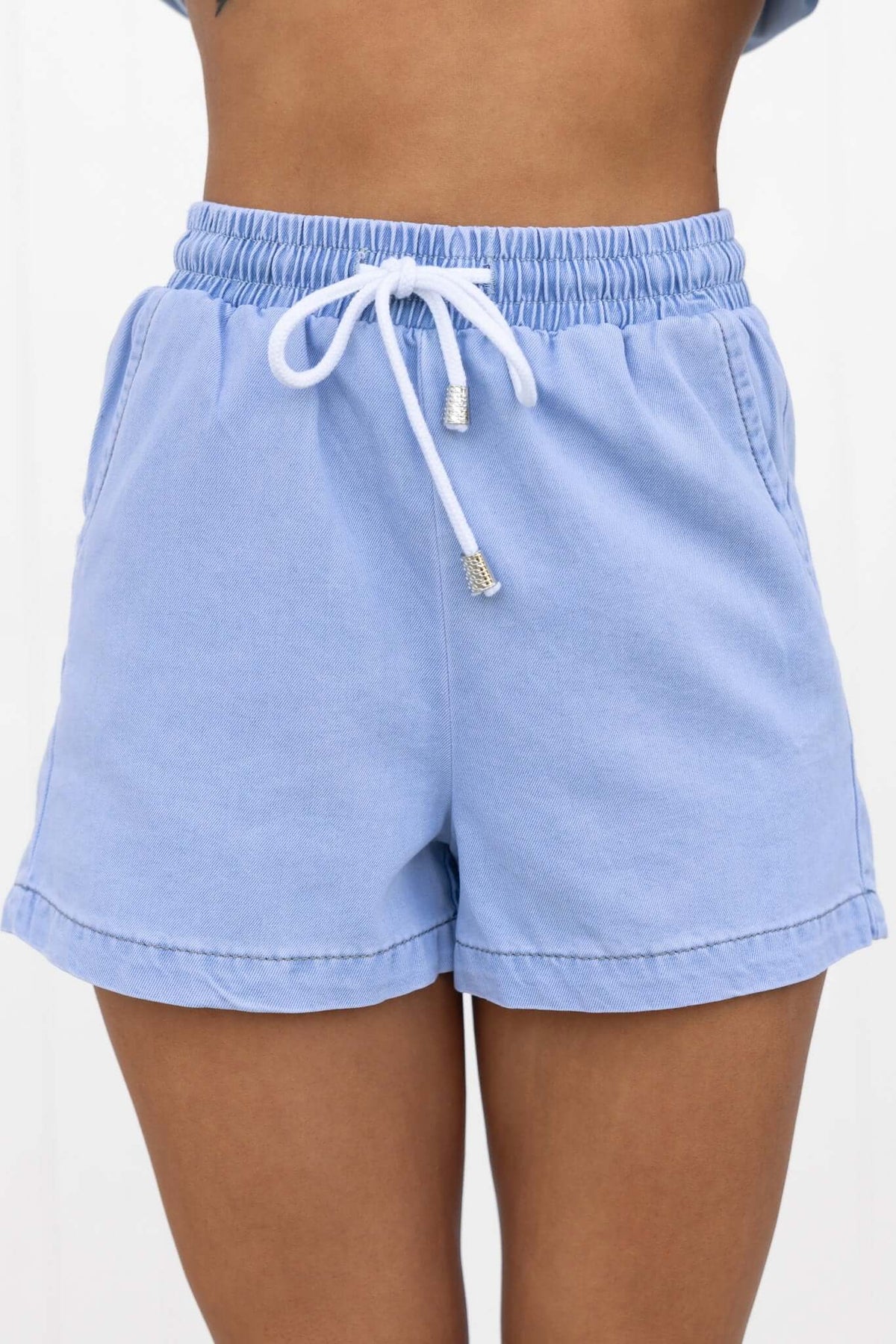 Winslow Shorts in light blue chambray with elastic waist, drawstring tie, and pockets, perfect for casual wear.