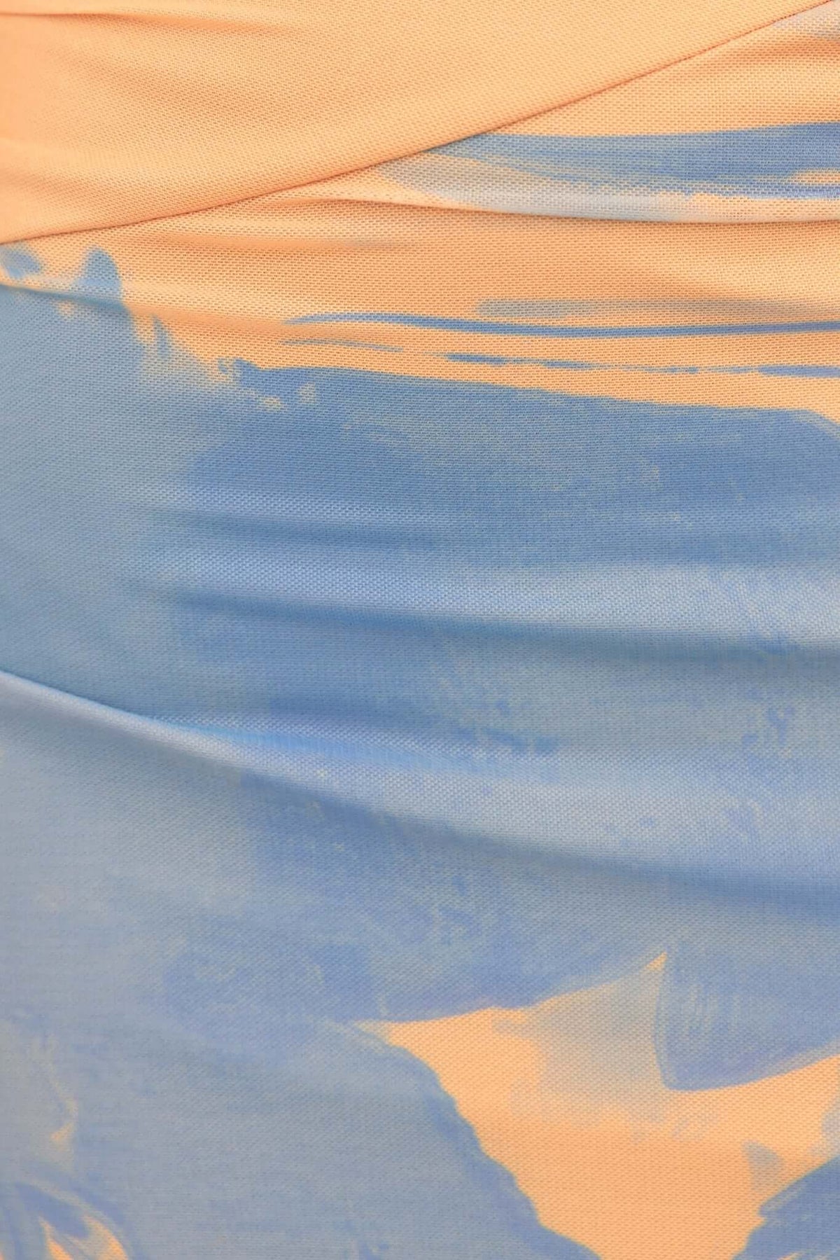 Close-up of Ovolo Maxi Dress fabric featuring a blend of soft orange and blue hues with rolled detail and stretch texture.
