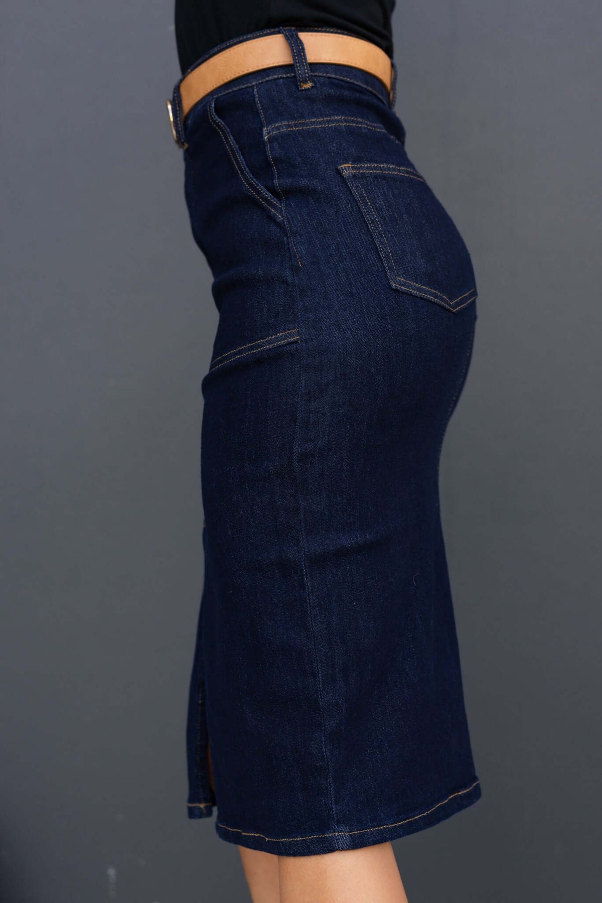 Side view of Ella Denim Midi Skirt in dark navy, showcasing mid-high waist and front split design.