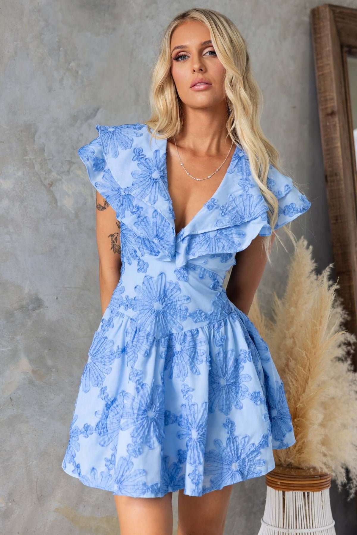 Olinda Dress in blue with floral detail, featuring ruffled sleeves and a tiered skirt, perfect for a summer outfit.