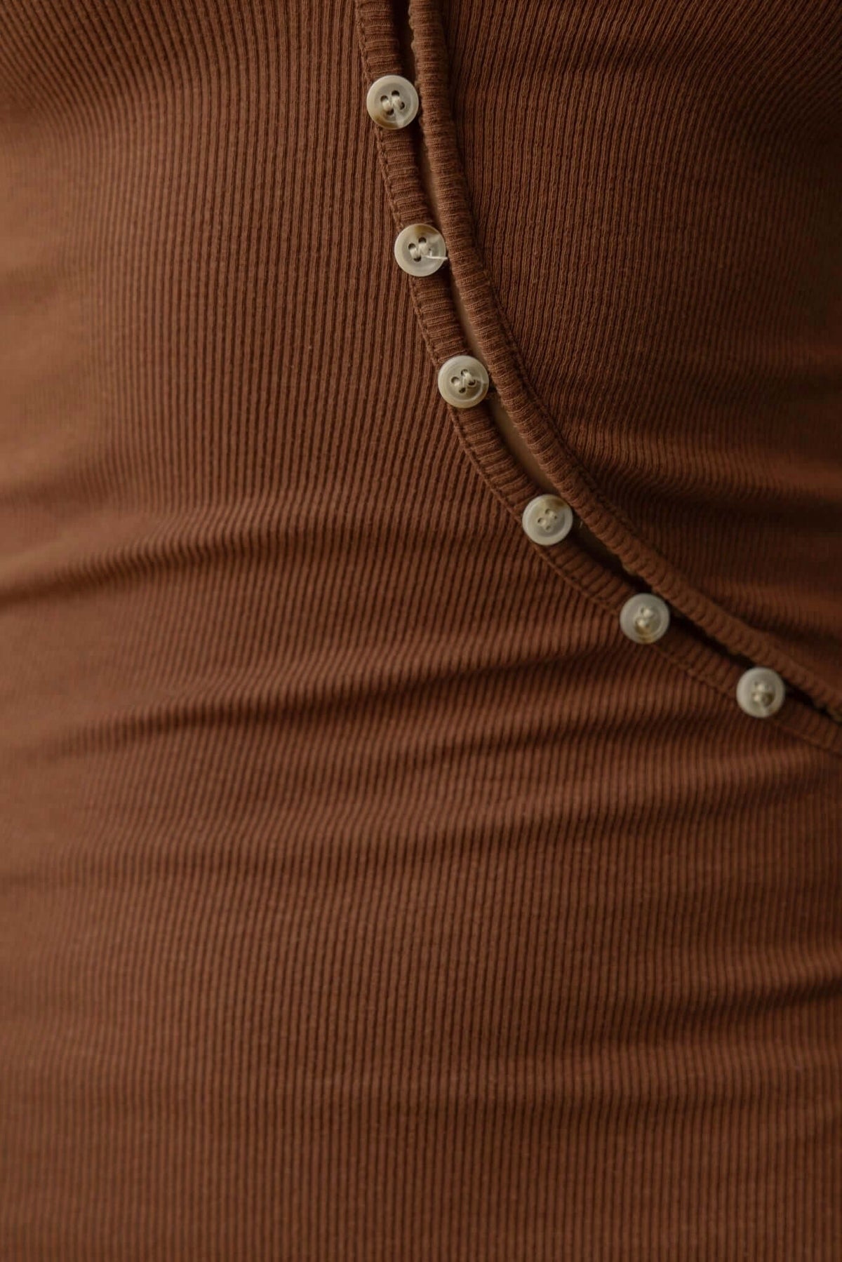 Close-up of Genna Midi Dress showing ribbed brown fabric and button-up detail.
