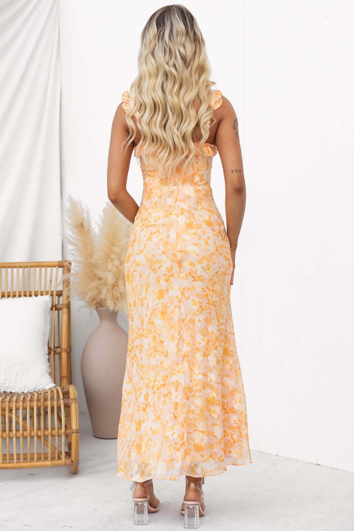 Model wearing a back view of a Fifth Street Maxi Dress with adjustable straps and floral pattern.