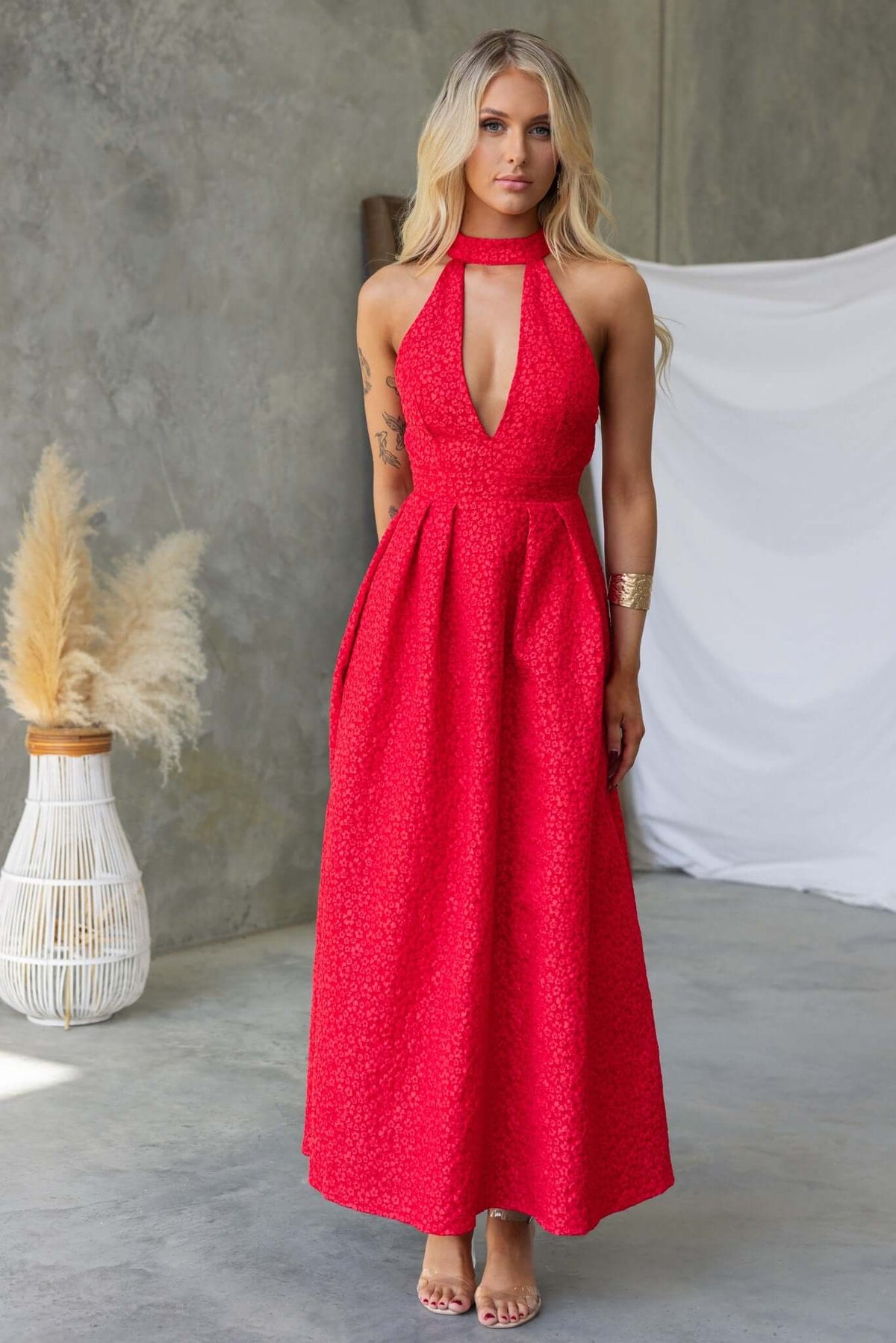 Ultima Maxi Dress in vibrant red with halter neck, pleated waist, and textured details for a chic look.