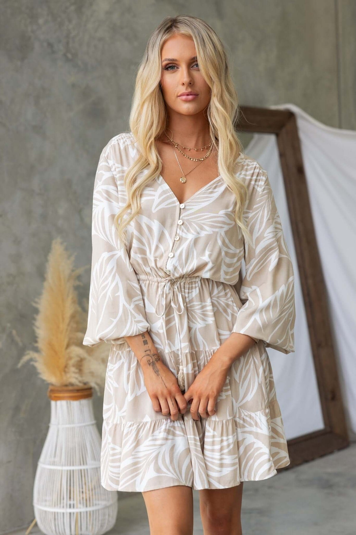Danza Dress featuring V-neckline, button-up bust, elastic waistband, pockets, and relaxed fit in a stylish floral pattern.