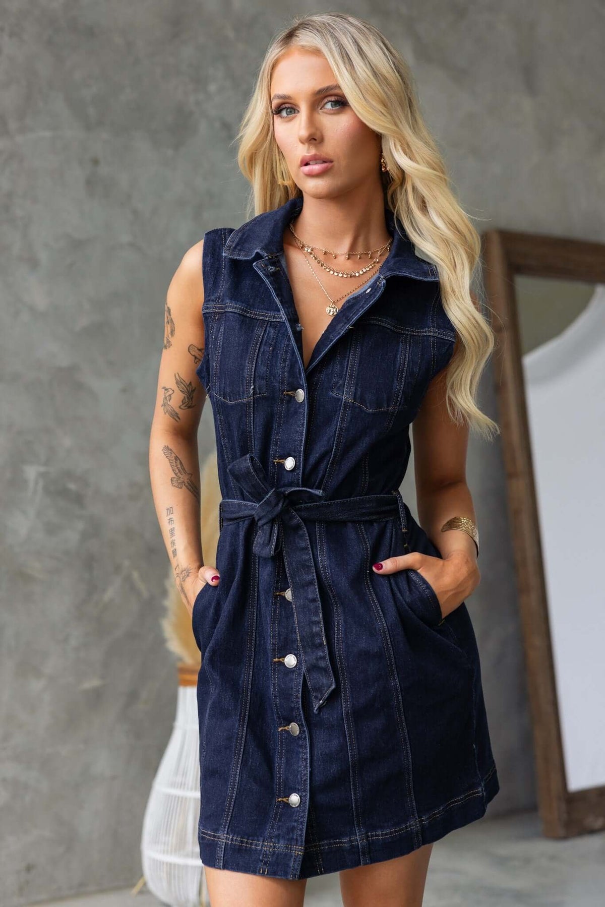 Model wearing a Pokey Denim Dress with collar, button-up front, and a removable belt, featuring pockets and stretch material.