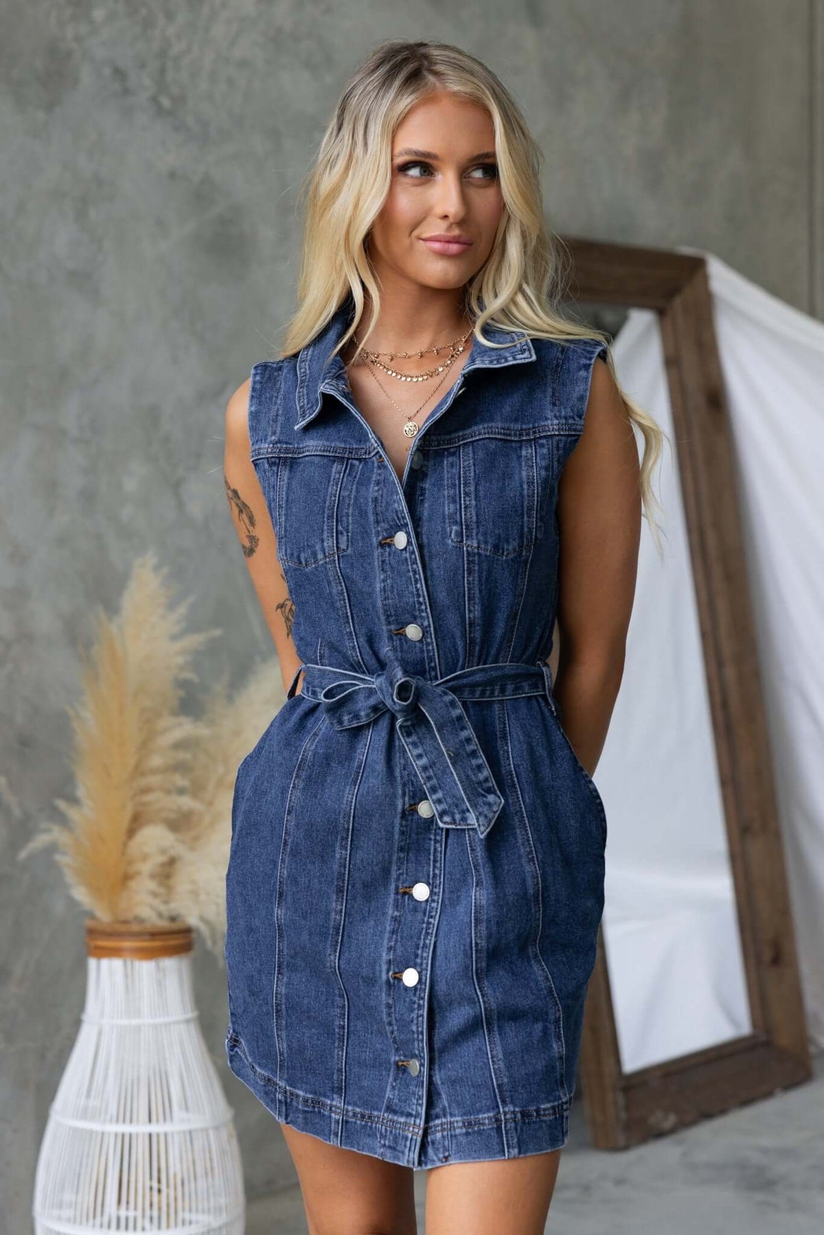 Model wearing a stylish Pokey Denim Dress with collar, button-up front, and removable belt, featuring a standard fit.