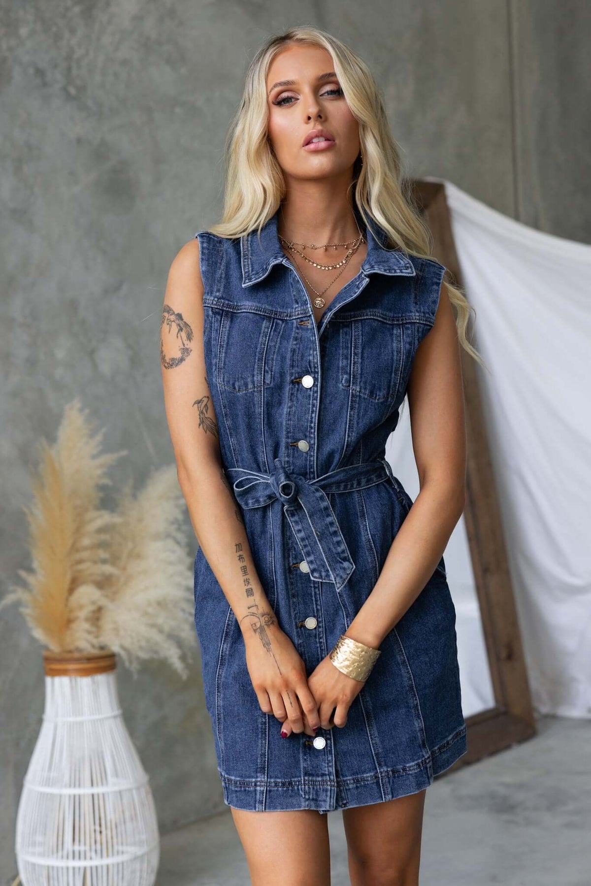 Model wearing a stylish Pokey denim dress with a collar, button-up front, and removable belt.