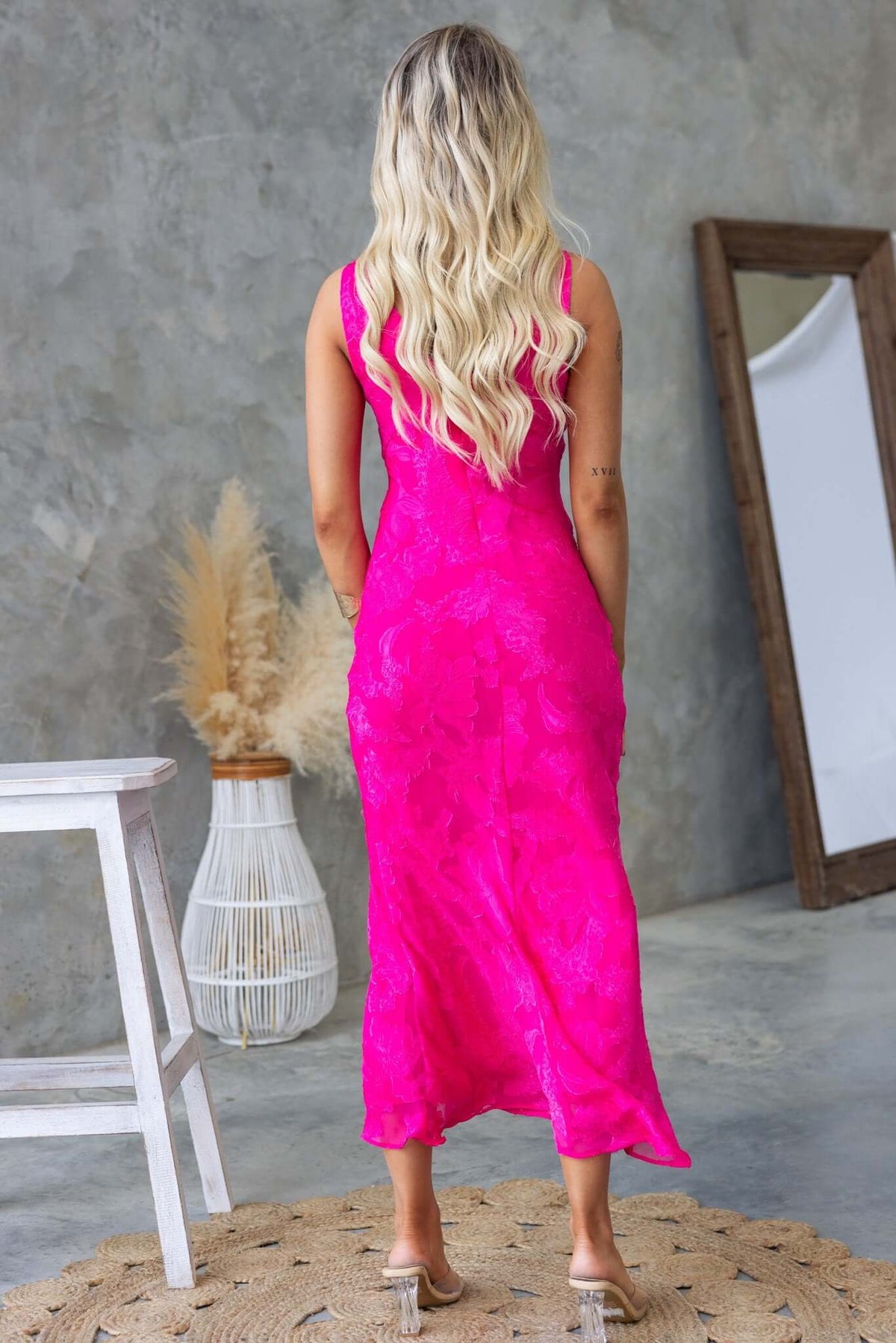 Back view of a model wearing a pink textured flower print Qilax Maxi Dress, perfect for any occasion.