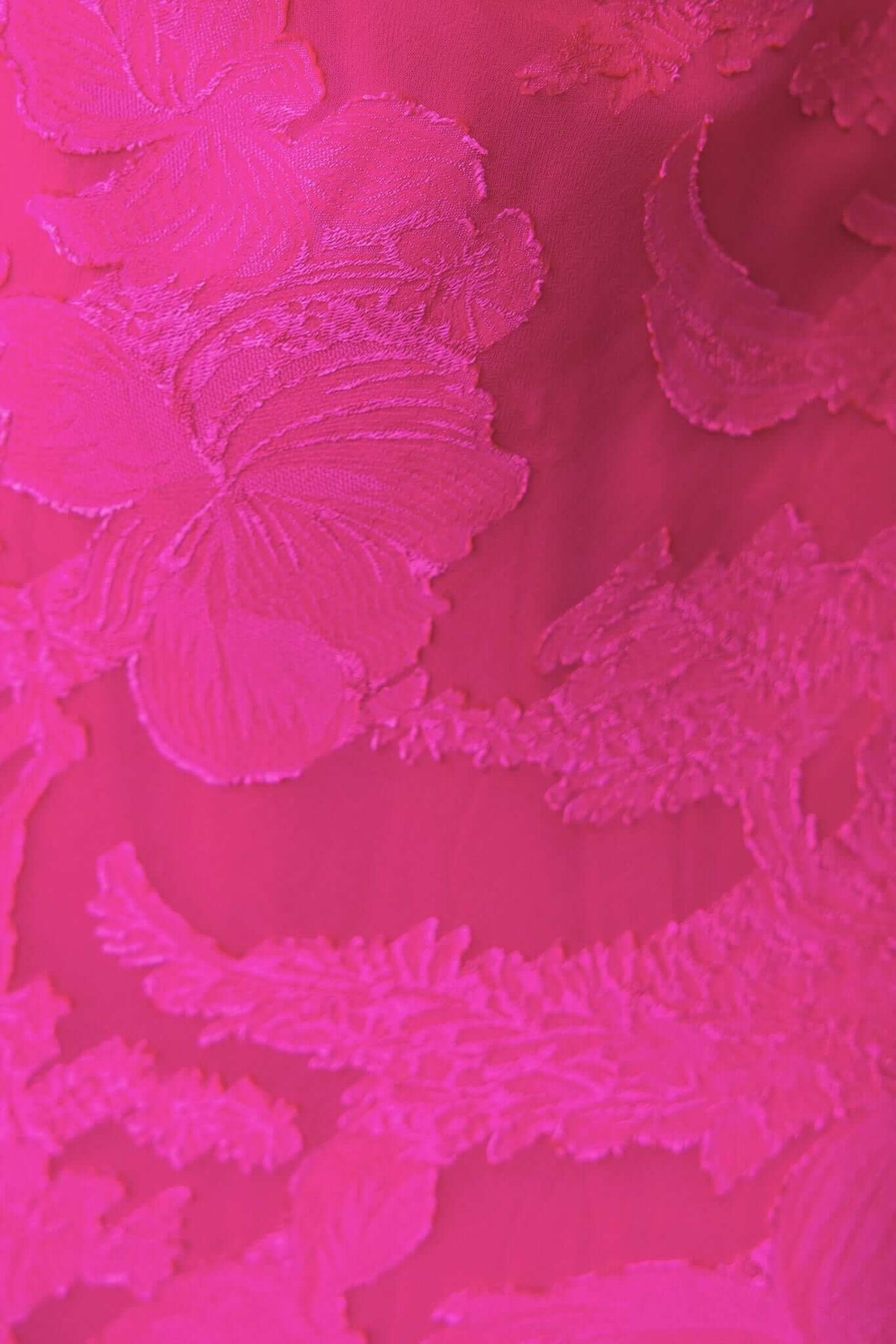 Textured flower print detail on vibrant pink fabric of Qilax Maxi Dress, showcasing intricate embroidery.
