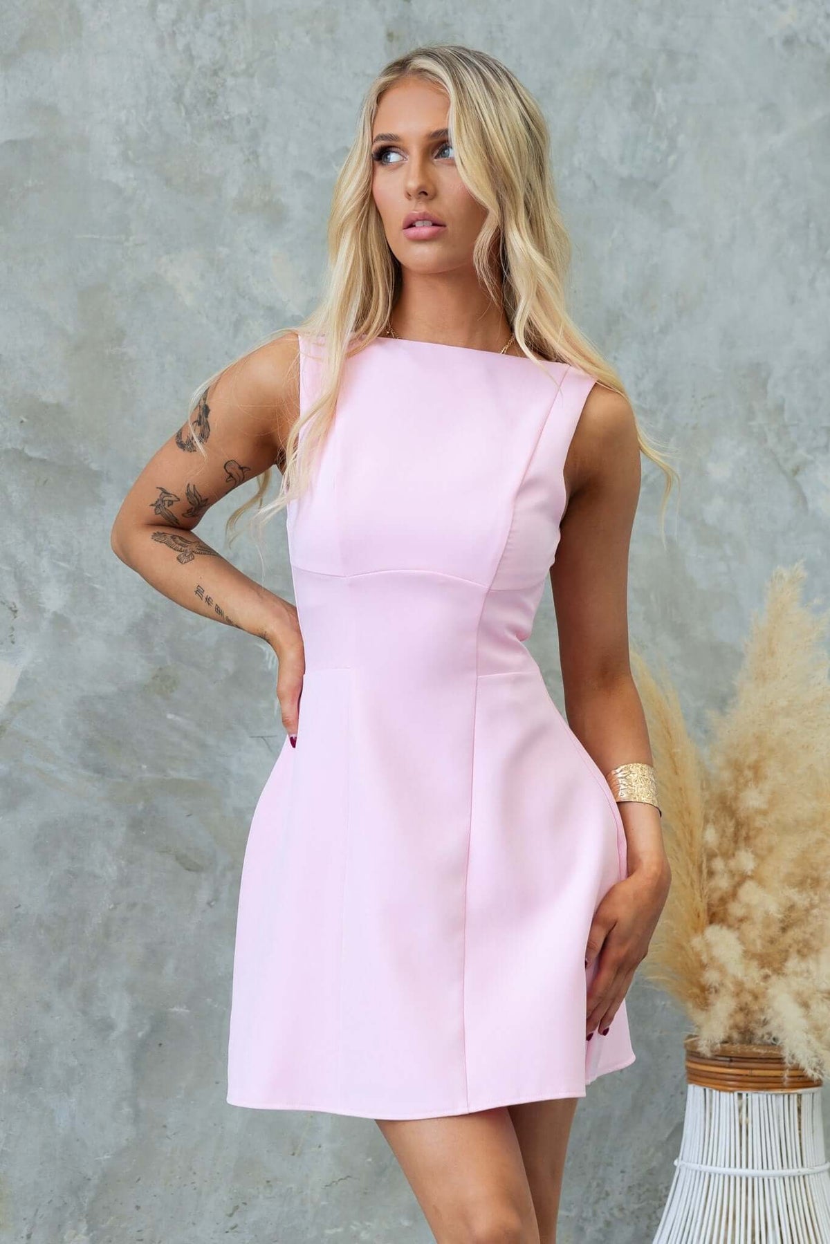 Model wearing a pink Demure Dress with scoop back and lined design, perfect for elegant occasions.