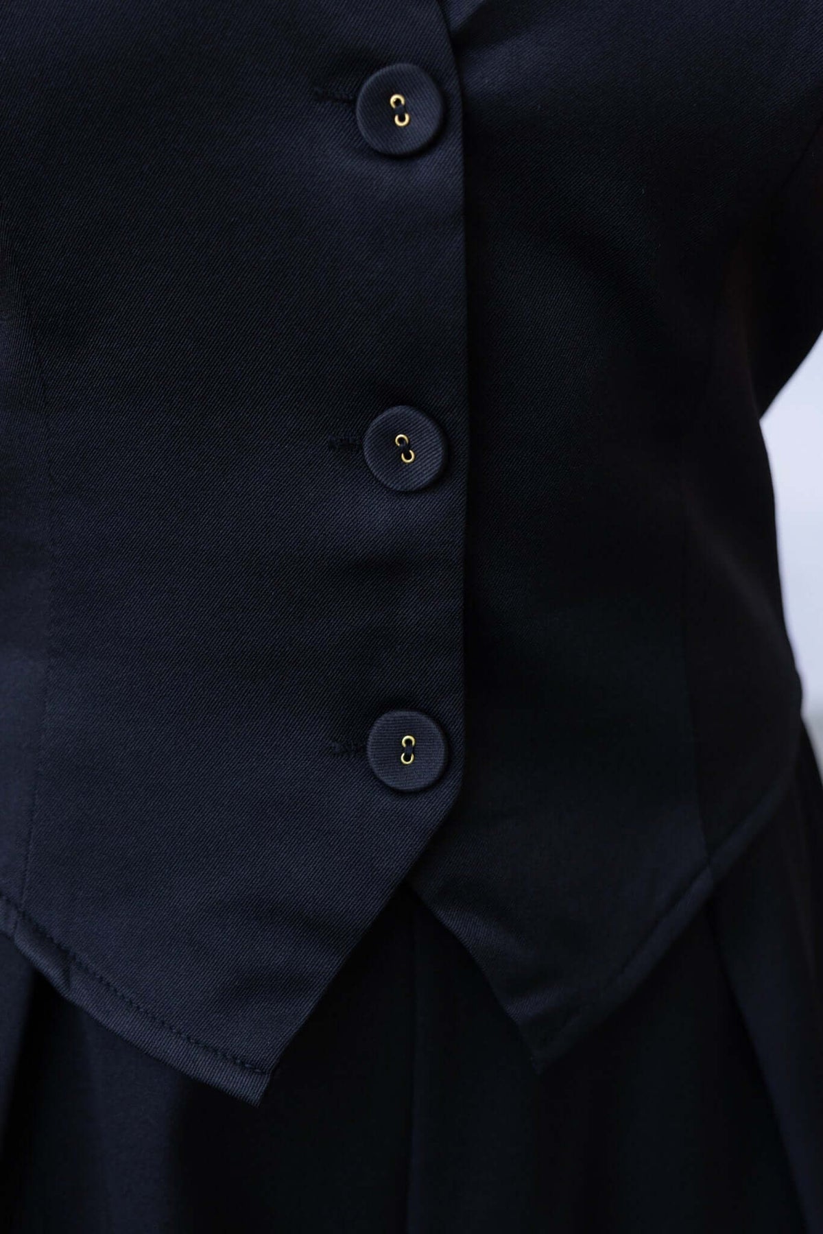 Close-up of the black Lennie Top featuring button-down front and stylish buckle at the back.