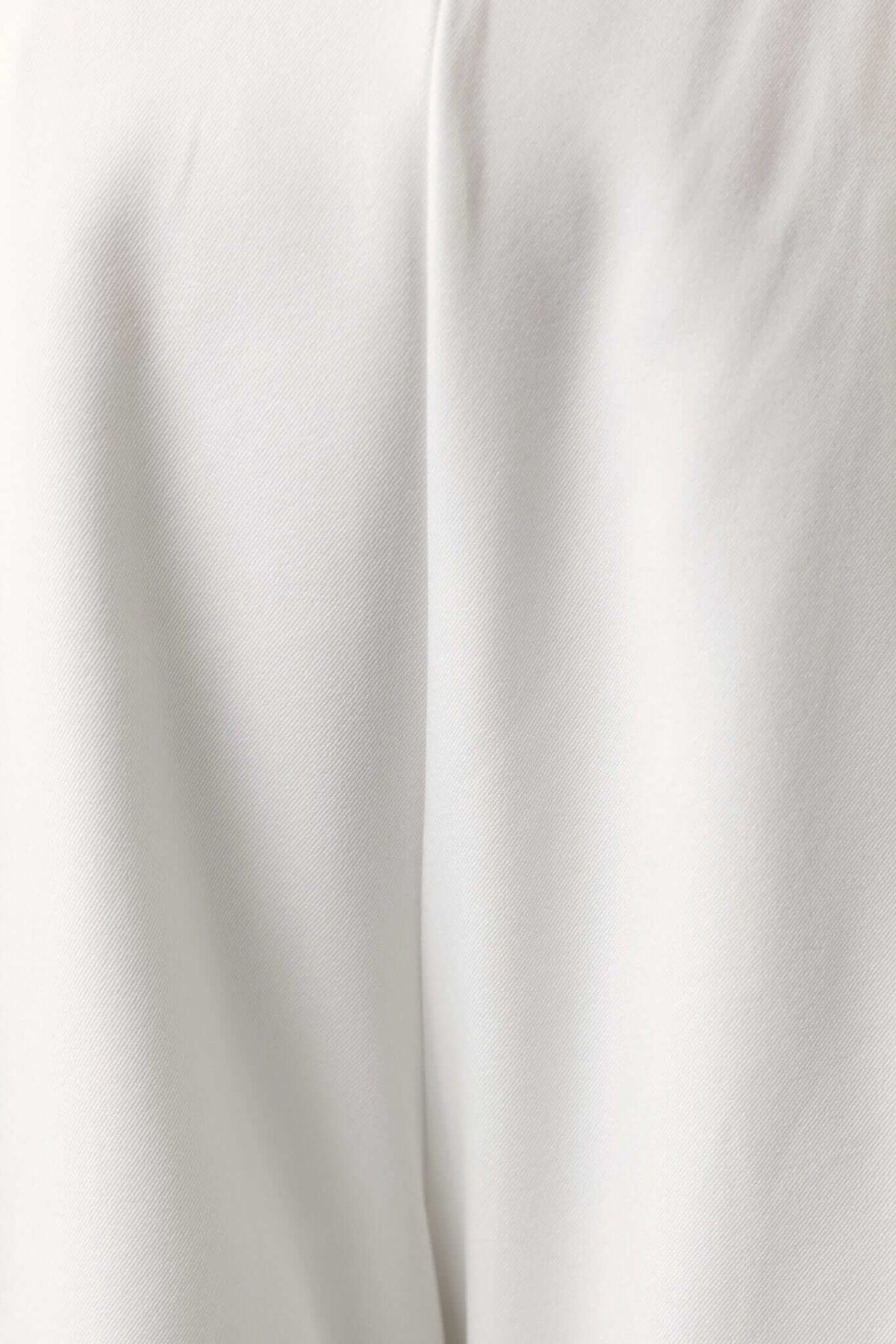 Close-up of the Lennie Top in white, featuring a smooth, non-stretch fabric for a sleek look.