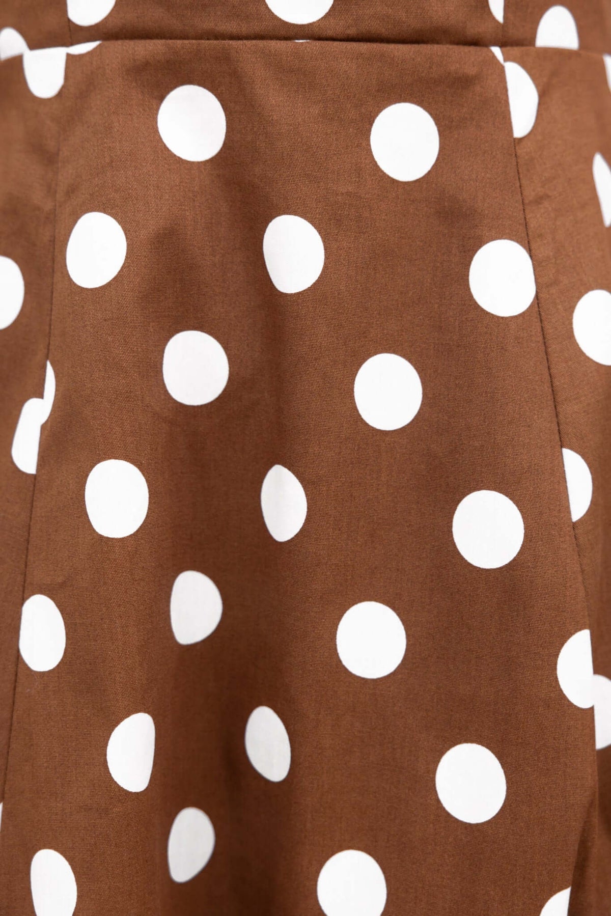 Brown midi dress fabric with large white polka dots, showcasing unique design and style details.